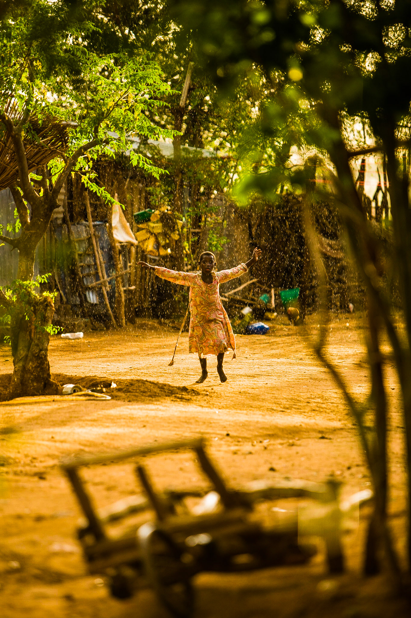 Dívka hrající si v dešti ze kterého má upřímnou radost.