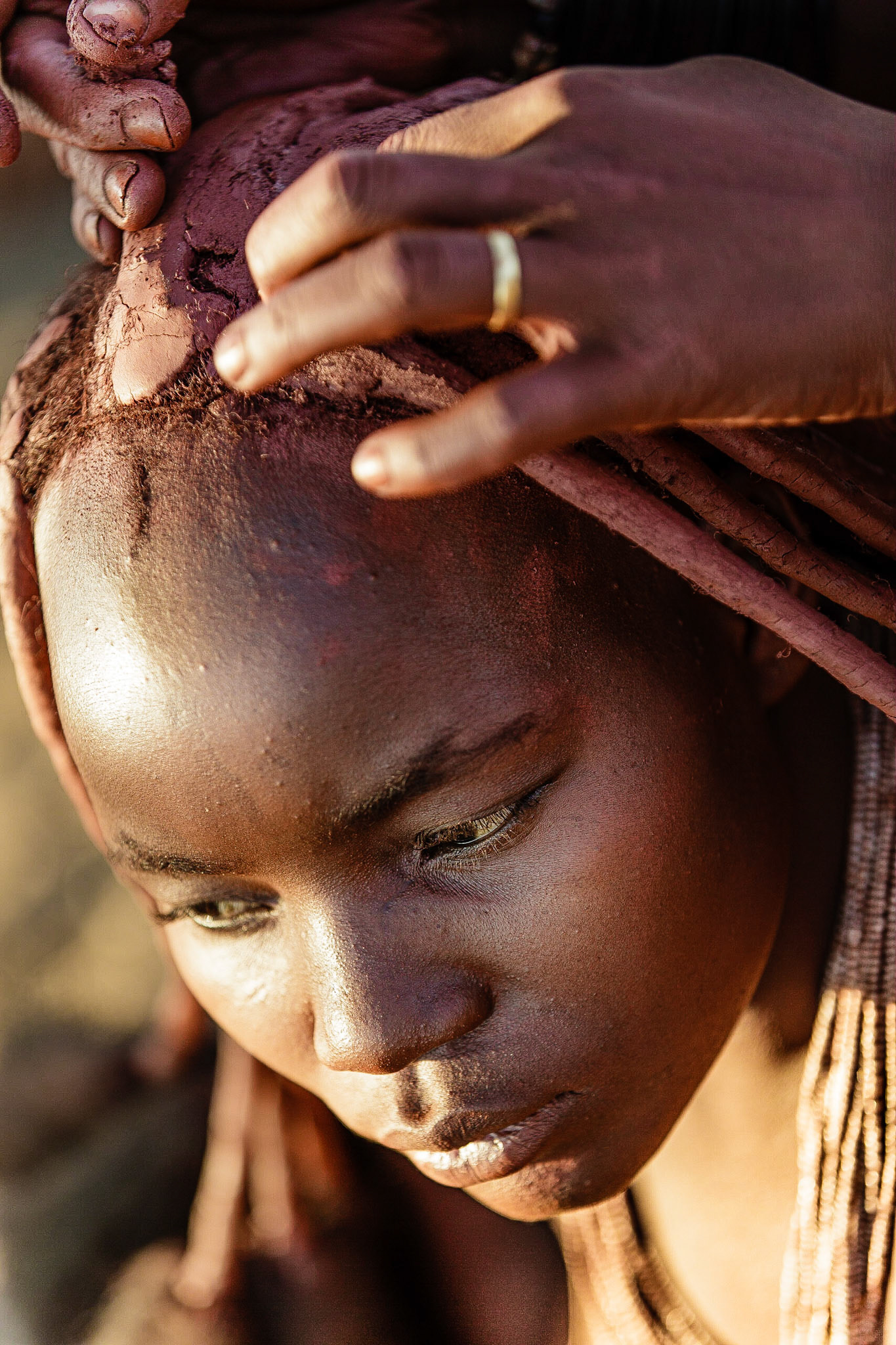 Připravené dredy se postupně obalují hliněnou směsí.