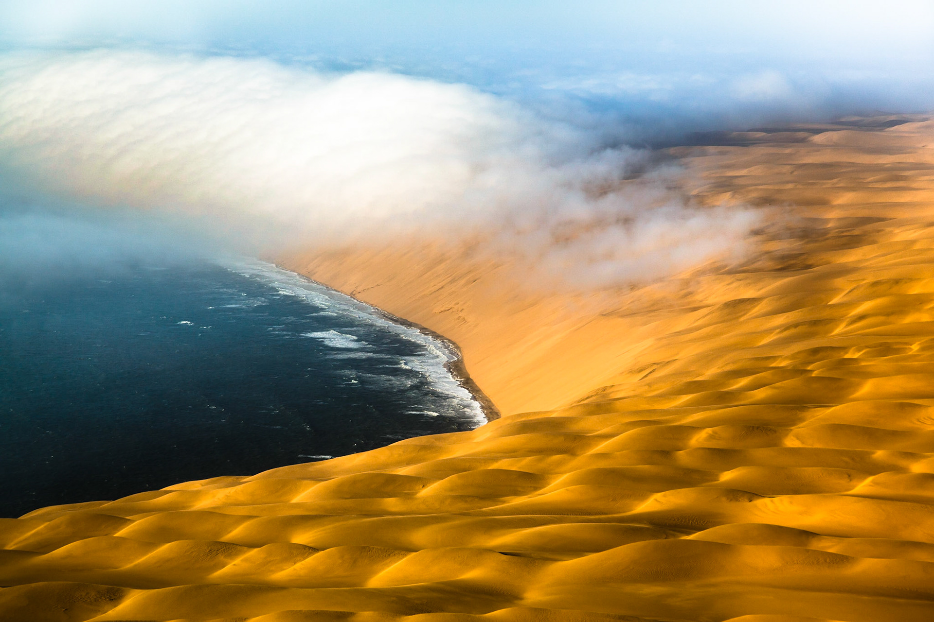 Skeleton Coast National Park - Namibia / Setkání živlů na jihozápadním pobřeží Afriky. Rozpálená poušť padající přímo do studeného oceánu, k tomu časté mlhy a silný vítr. To je recept na opravdu nehostinné pobřeží, kterému se ne nadarmo přezdívá Pobřeží koster. Zbytky tuleňů, rezivějící vraky lodí, jež si postupně bere pod svá křídla písek, ale i lidské ostatky, které naopak odhaluje prudký vítr naznačují, odkud název Skeleton Coast pochází.