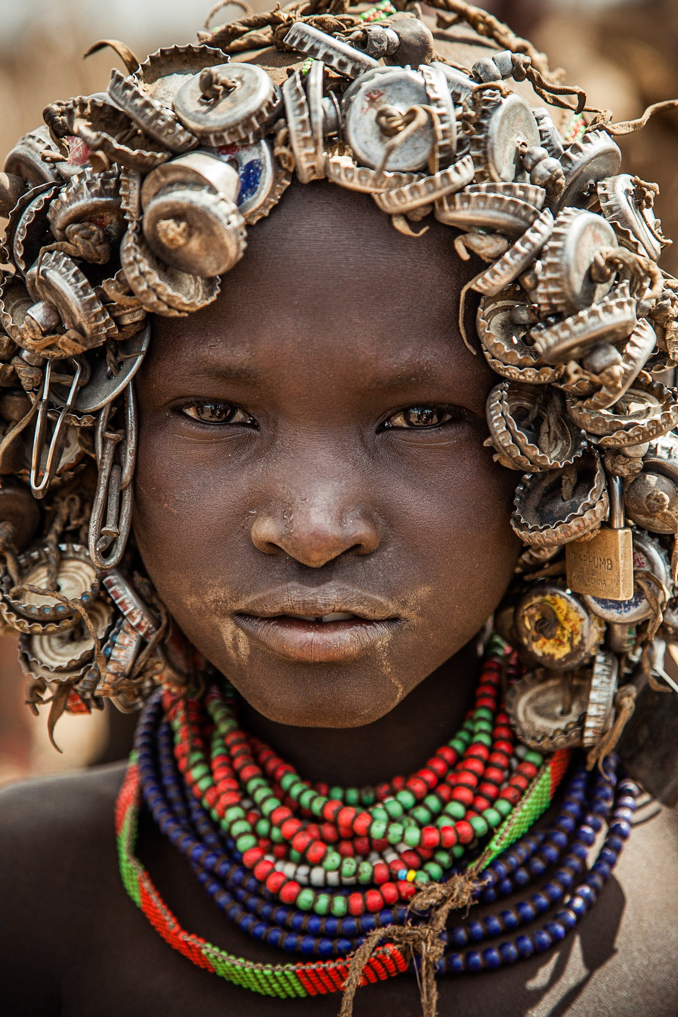 Děti si na hlavu navlečou leccos, aby přesvědčily turisty, že právě ony stojí za  fotku, za kterou pak zinkasují 3 birry.