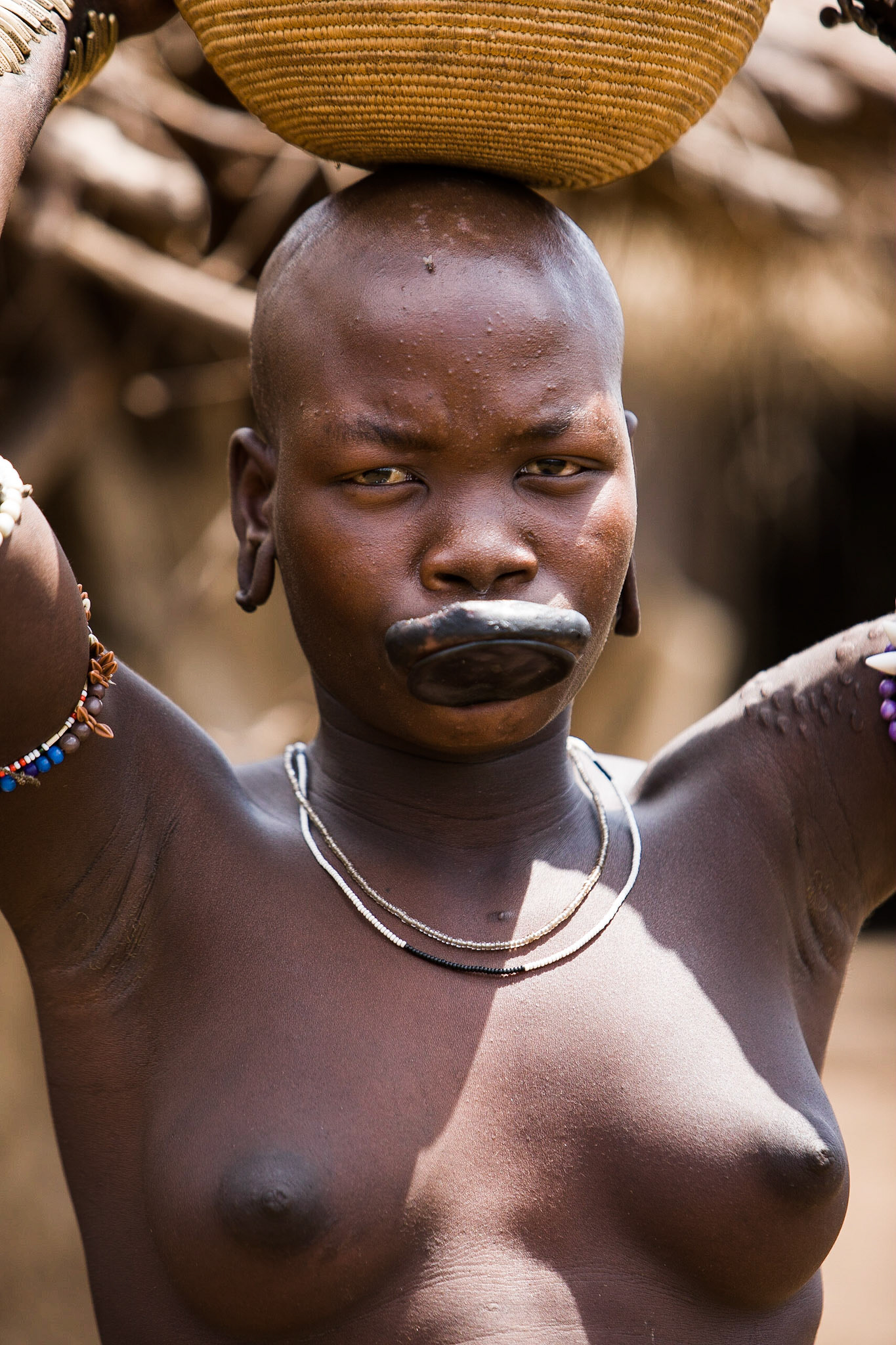 Talířky ve spodním rtu a ušních lalůčcích jsou nejen ozdobou, ale i obchodním artiklem.