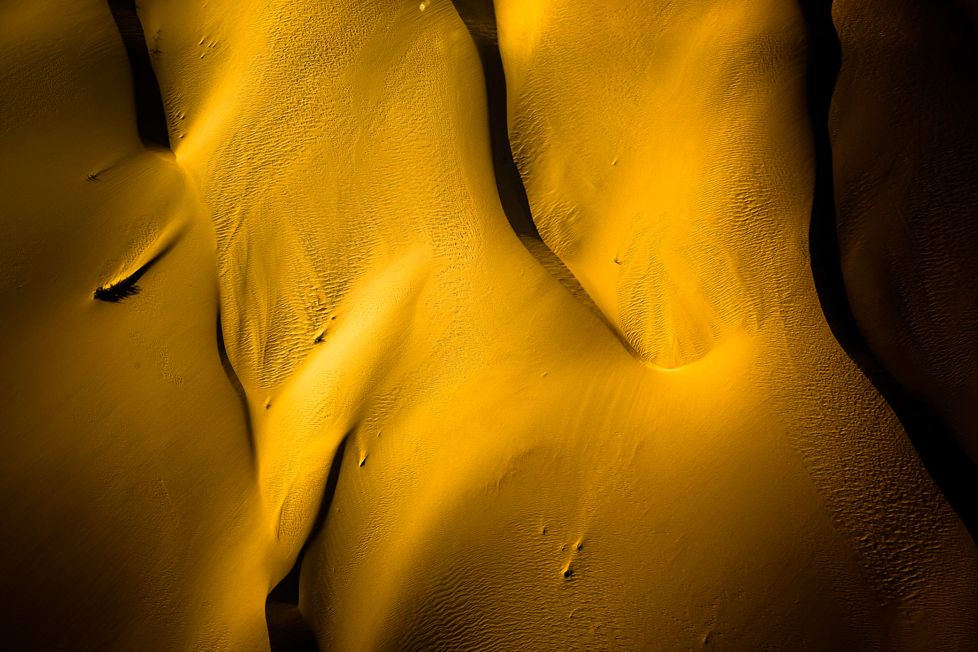 Pohled až na 300 metrů vysoké duny jedné z nejstarších pouští světa ze vzduchu odhalí, kolik tváří může mít písek v kombinaci se zapadajícím sluncem.