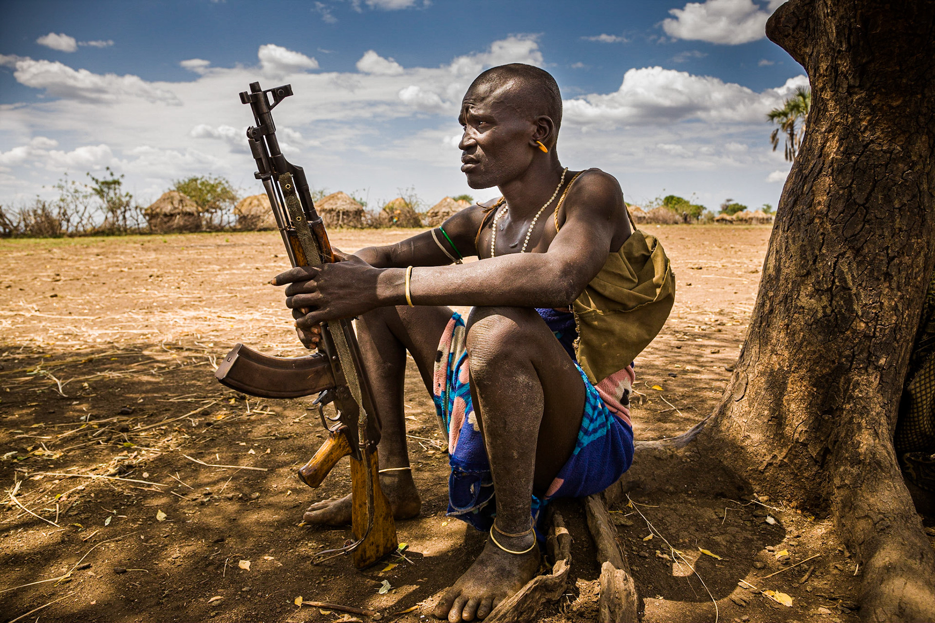 Muži se rádi shlukují ve stínu stromů před vesnicí. Povídají si a živě mezi sebou mávají ostře nabitými kalašnikovy.