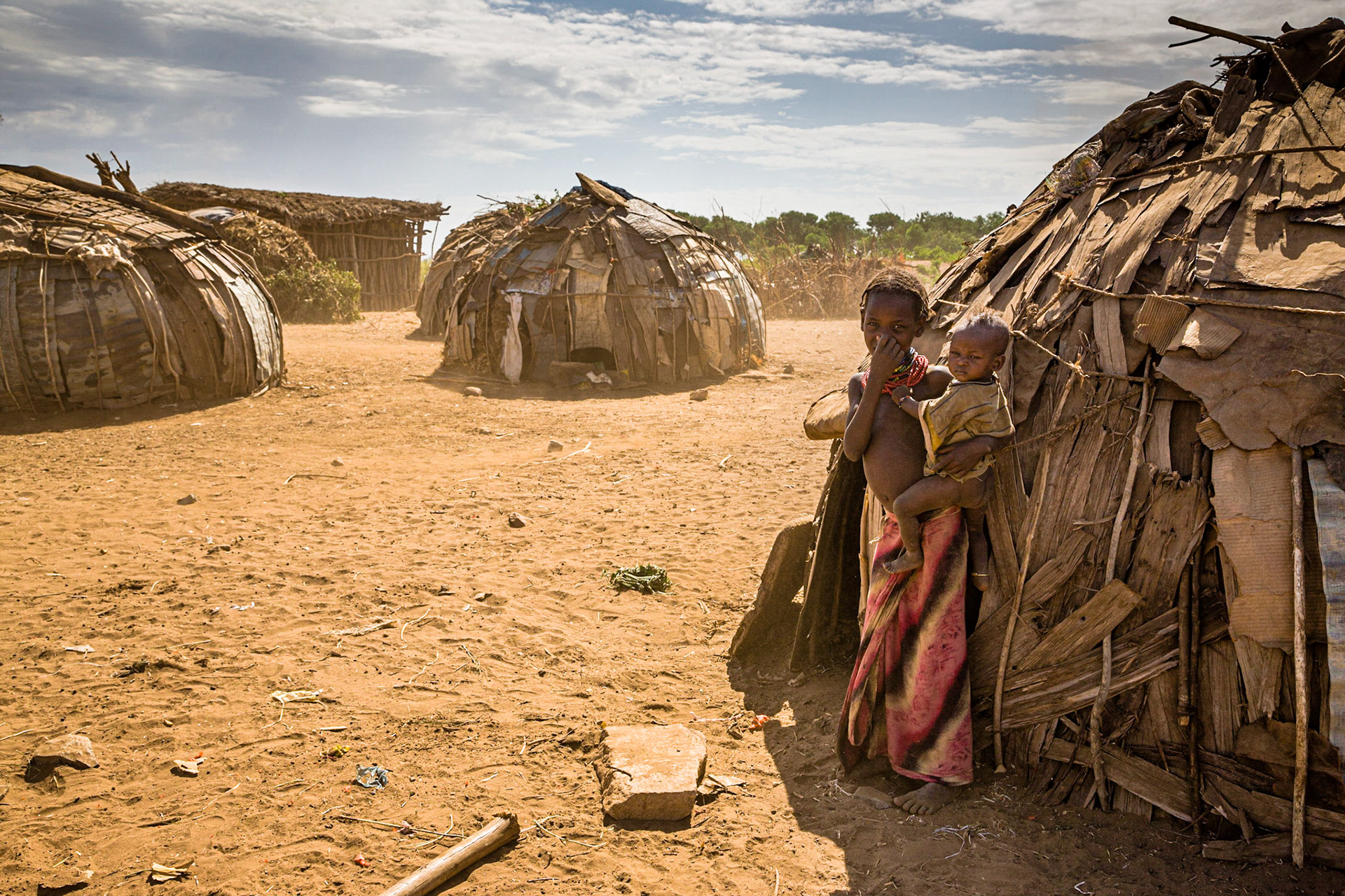 Vesnice kmene Galeb v prašném prostředí na břehu řeky Omo.