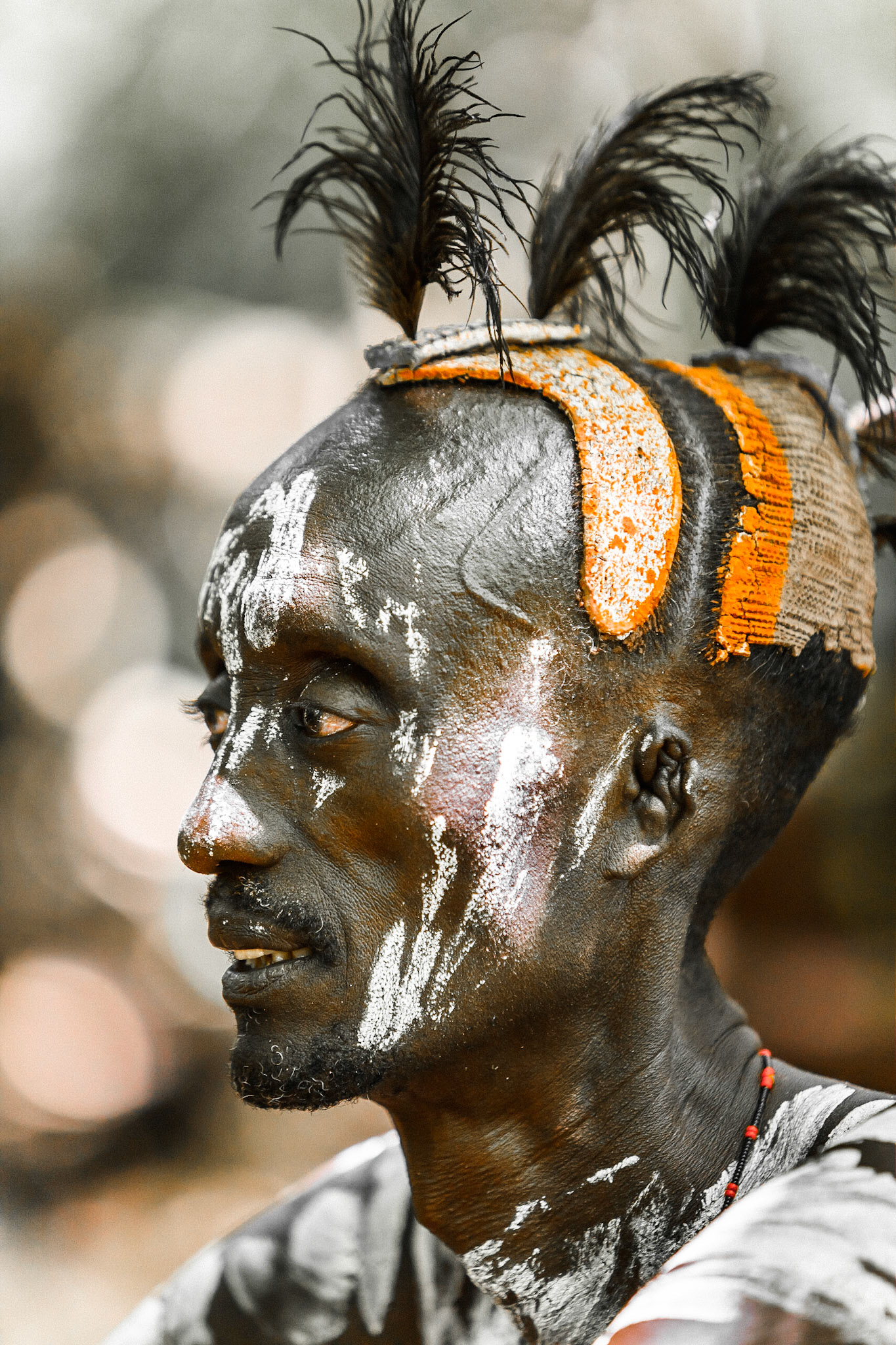 Karo tribe - Omo Velei - Ethiopia / Muž z kmene Karo s typickou výzdobou. S populací cca 1500 členů je kmen Karo jednou z těch menších skupin původních obyvatel, jež se vyskytují v etnicky velice pestré oblasti údolí řeky Omo. Specifická výzdoba hlavy je tvořena směsí různých barevných jílů a tuku. Některé z těchto jílů jsou poměrně drahé a dovážejí se z větších vzdáleností, a tak si místní obyvatelé ve spánku podpírají hlavy jednoduchými stoličkami, aby svou pracnou a drahou výzdobu ihned neponičili.