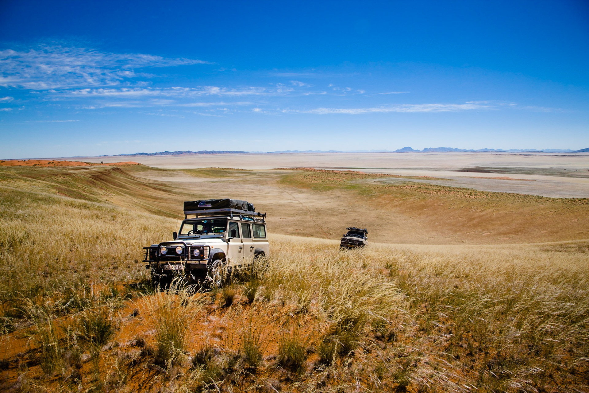 Začátek naší cesty npříč pouští Namib. Před oblastí s obrovskými červenými dunami se rozkládá rozhlehlá část pouště porostlá stříbřitou trávou, kde se prohánějí stáda oryxů.
