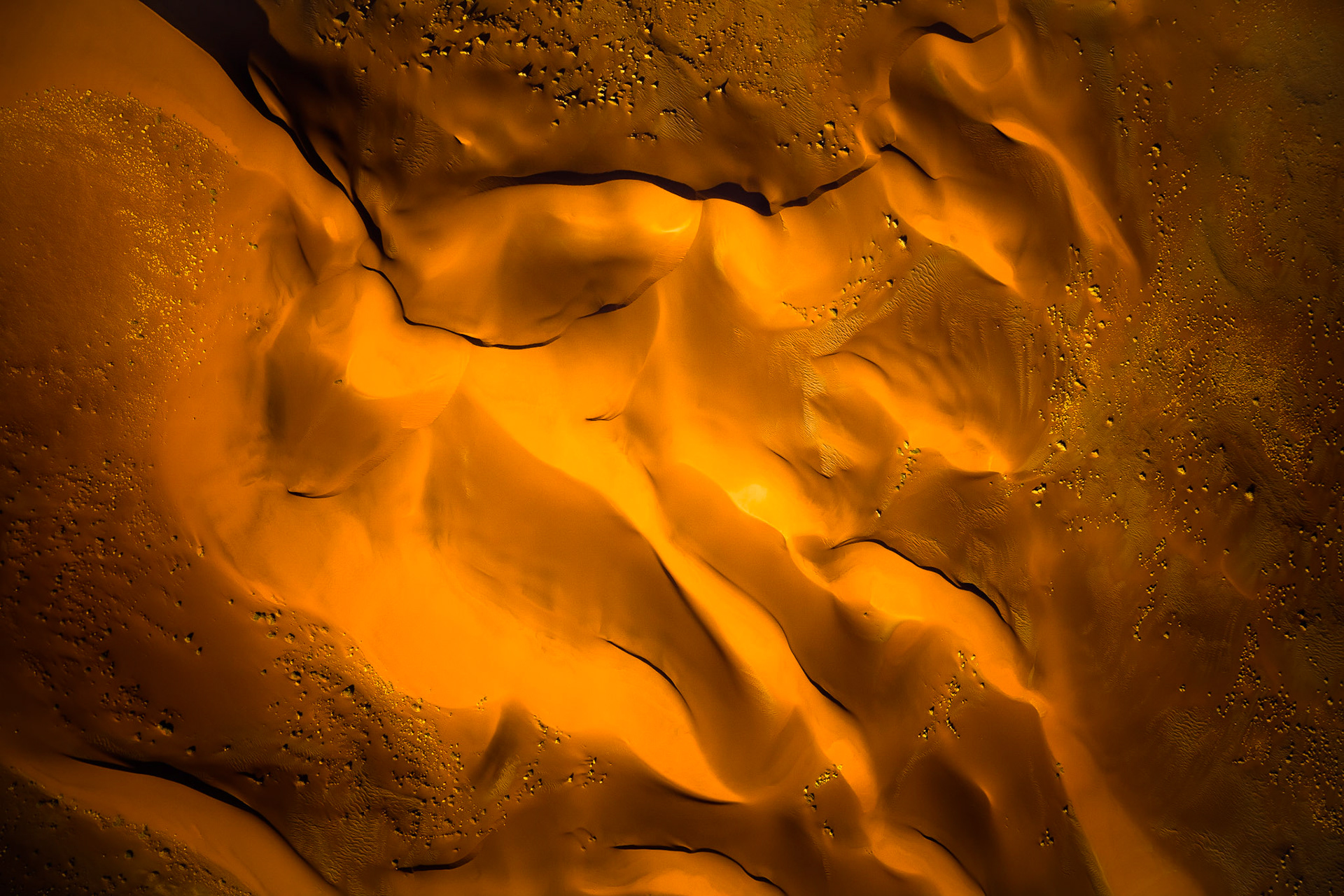 Pohled až na 300 metrů vysoké duny jedné z nejstarších pouští světa ze vzduchu odhalí, kolik tváří může mít písek v kombinaci se zapadajícím sluncem.