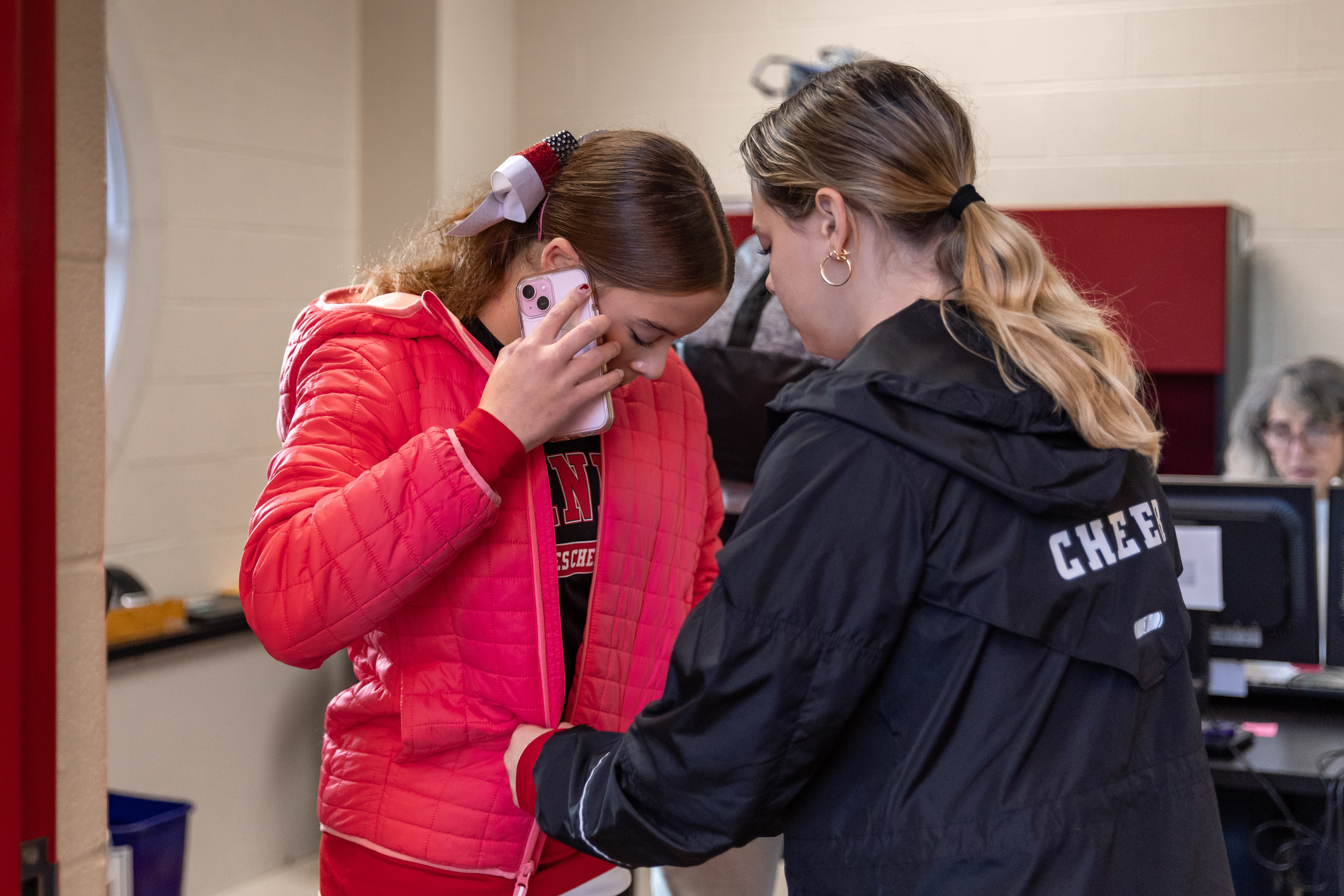 Kaydance Provost-Lutz, right, a cheer teammate, helps Abbey put on her jacket. The surgery and cardiac arrest have created physical limitations for Abbey including the inability to lift her left arm above 90 degrees, carry more than 10 pounds, and participate in activities that elevate her heart rate.