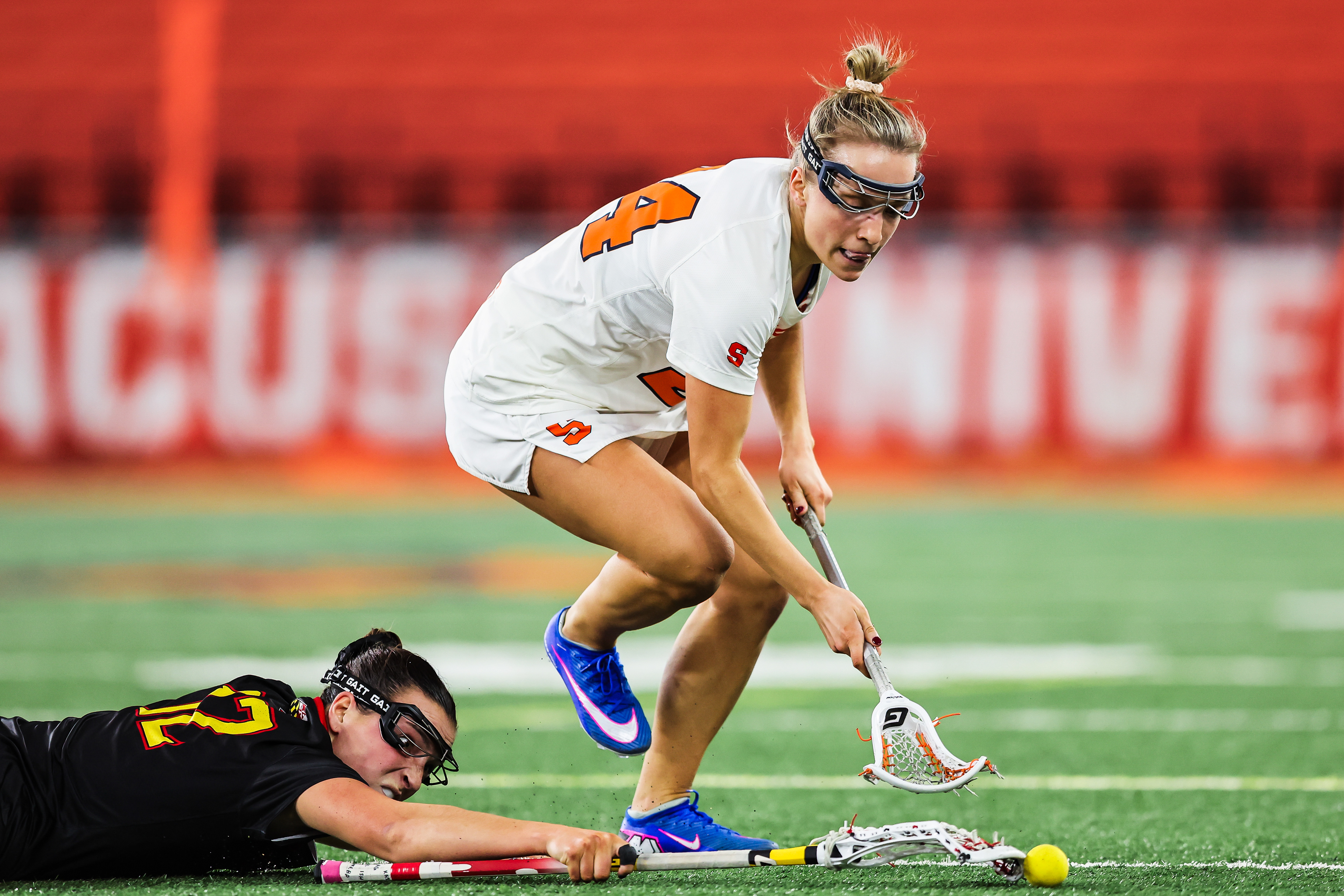 Syracuse midfielder Caroline Trinkaus (24) battles Maryland defenseman Annabelle Schafer (12) for possession of the ball during a college lacrosse game on Feb. 6, 2026, in Syracuse, N.Y.