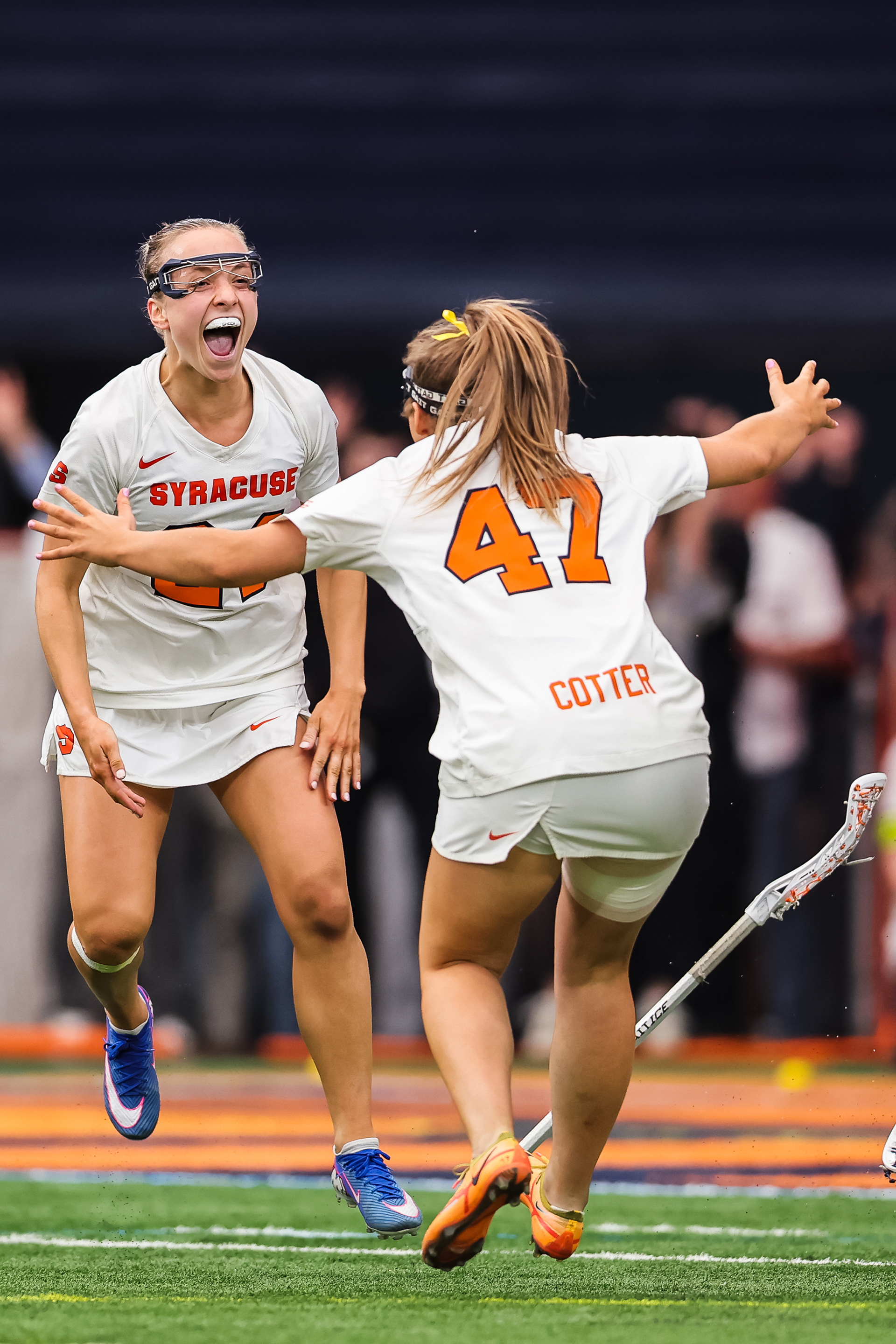 Syracuse University's Caroline Trinkaus (24) and Mileena Cotter (47) celebrate Trinkaus’ game-winning goal in fourth overtime against Notre Dame on April 11, 2026, in Syracuse, N.Y.