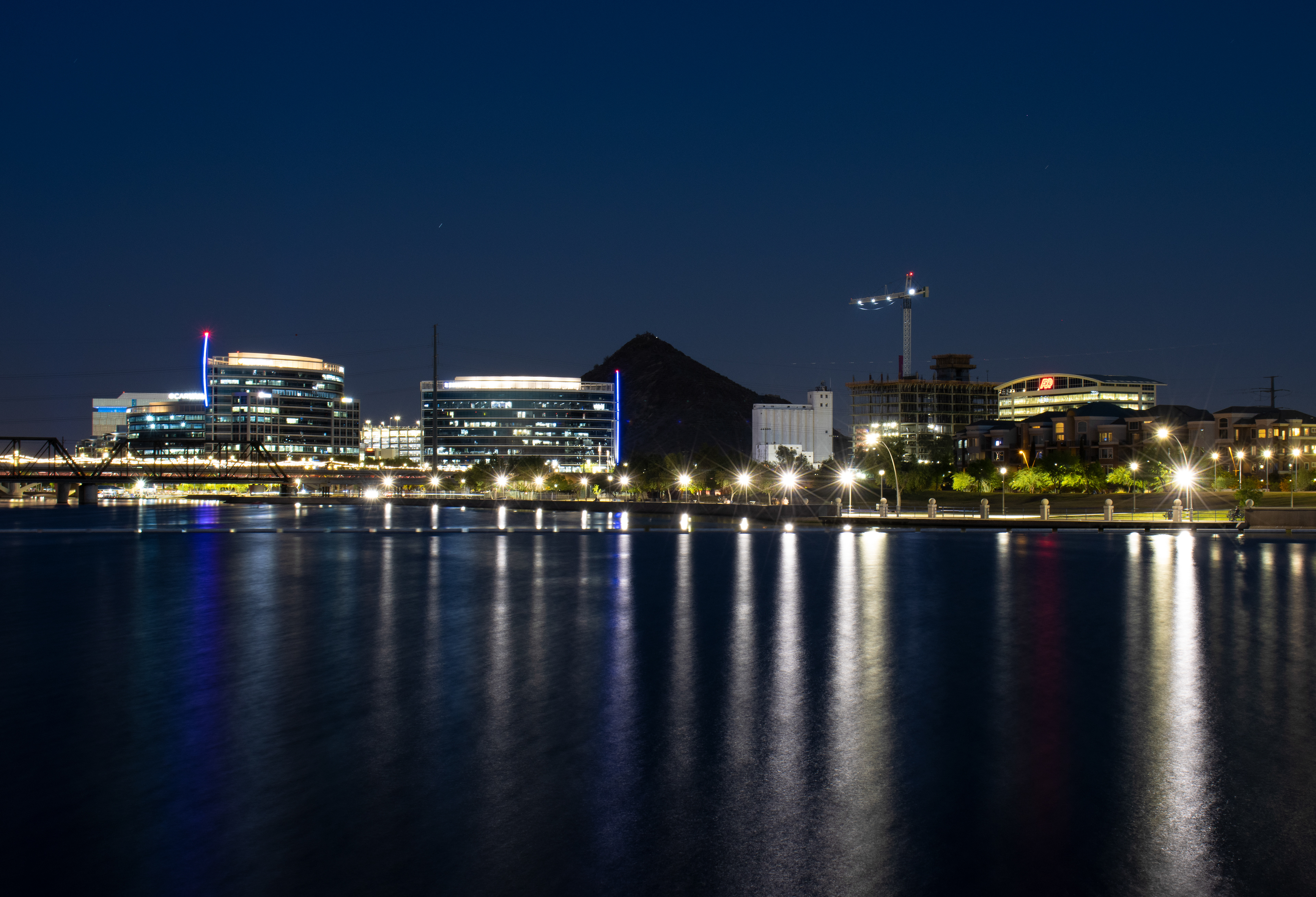 Nearby buildings and streetlights illuminate Tempe Town Lake just after sunset on April 12, 2021.