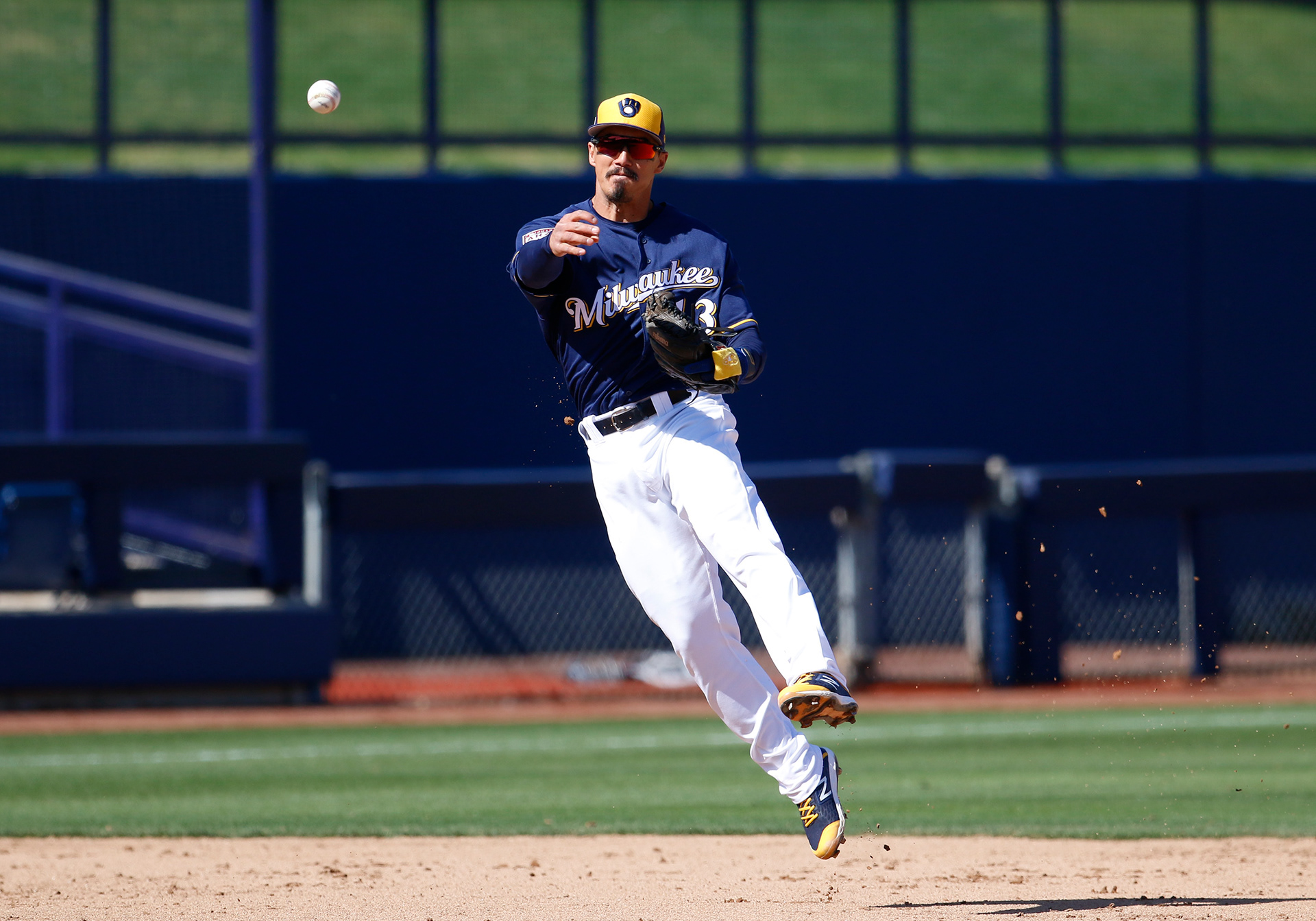 Milwaukee Brewers shortstop Tyler Saladino makes a leaping throw to first base during a spring training game against the Cleveland Indians on March 13, 2019, in Phoenix.