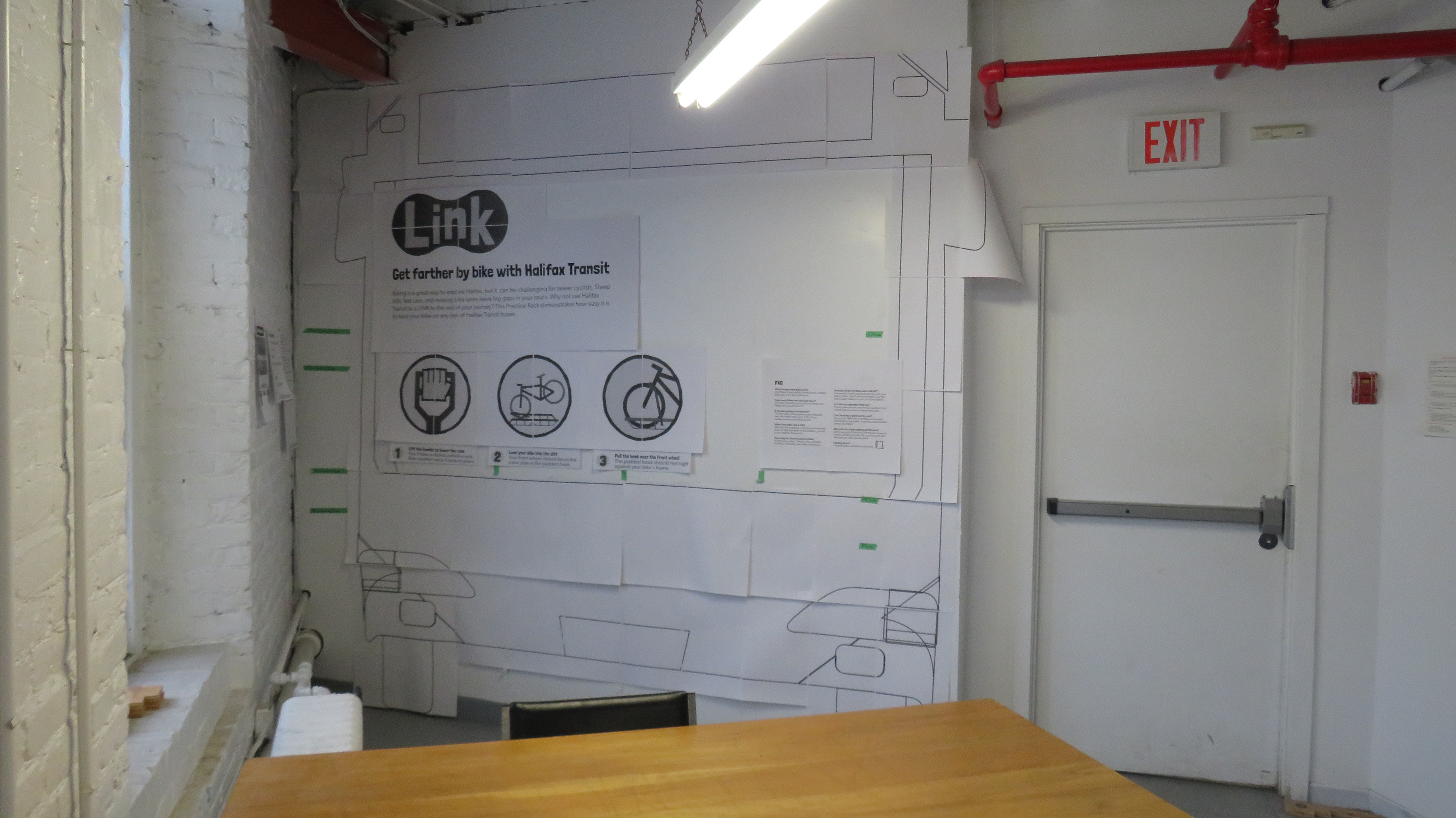 Basic mock-up of the informational display to scale. the ceilings were slightly too small to display the full height of the signage, and I have limited the layout to where I can comfortably reach. The green tape marks different zones on my signage to help me navigate as I test different layouts. This bus was made by printing parts of the bus on sheets of paper and piecing them together like an oversized puzzle. In future projects, I would like to try a less time consuming, more accurate approach.