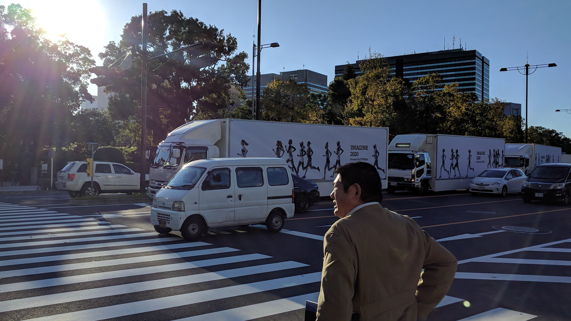 Ikeji Uju: Business man crossing the street in front Hibiya park in Chiyoda City, Tokyo, Japan. Ikeji Uju Photography