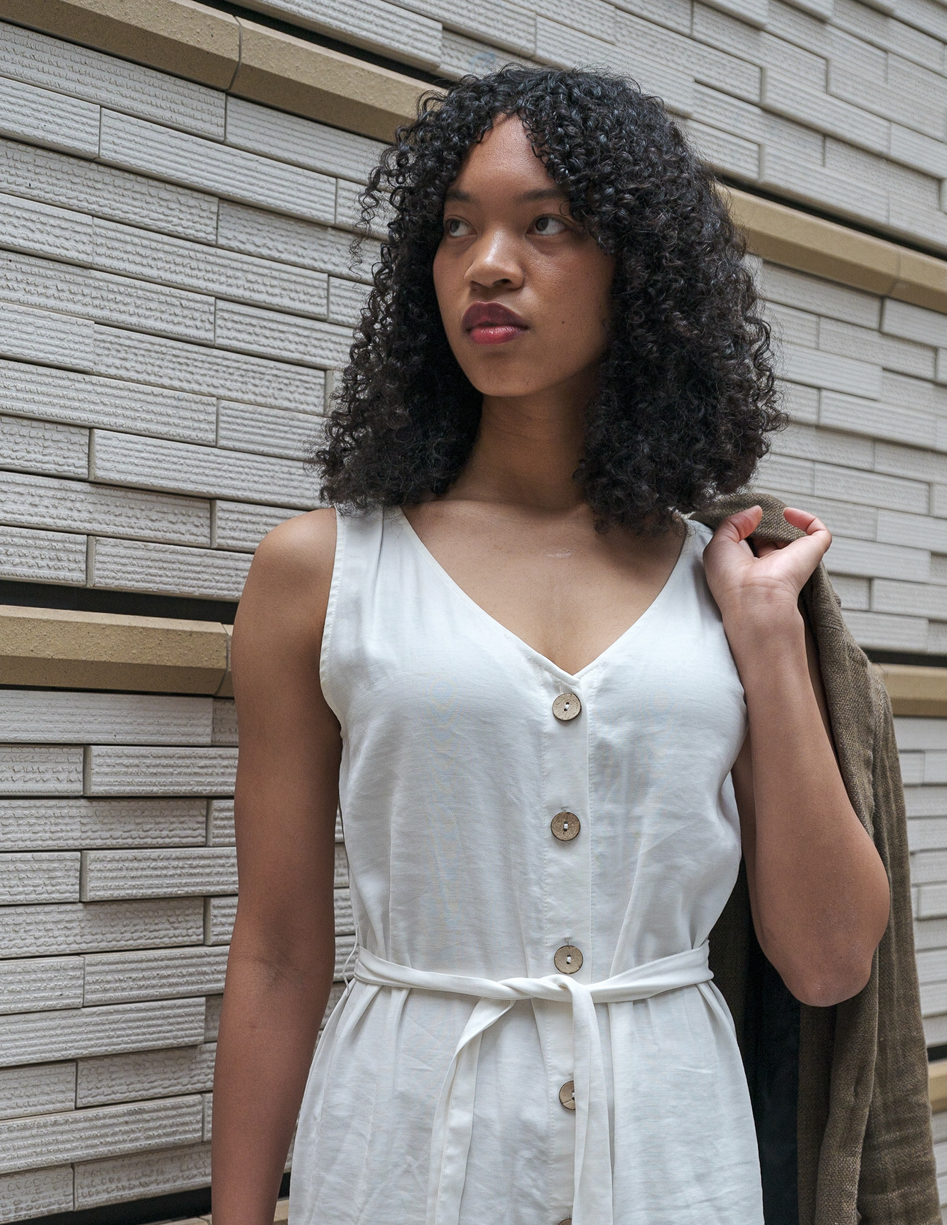 Ikeji Uju: Emily Osas elegantly adorned in a brown linen coat and white one-piece dress, set against the backdrop of Tokyo, Japan. Ikeji Uju Photography