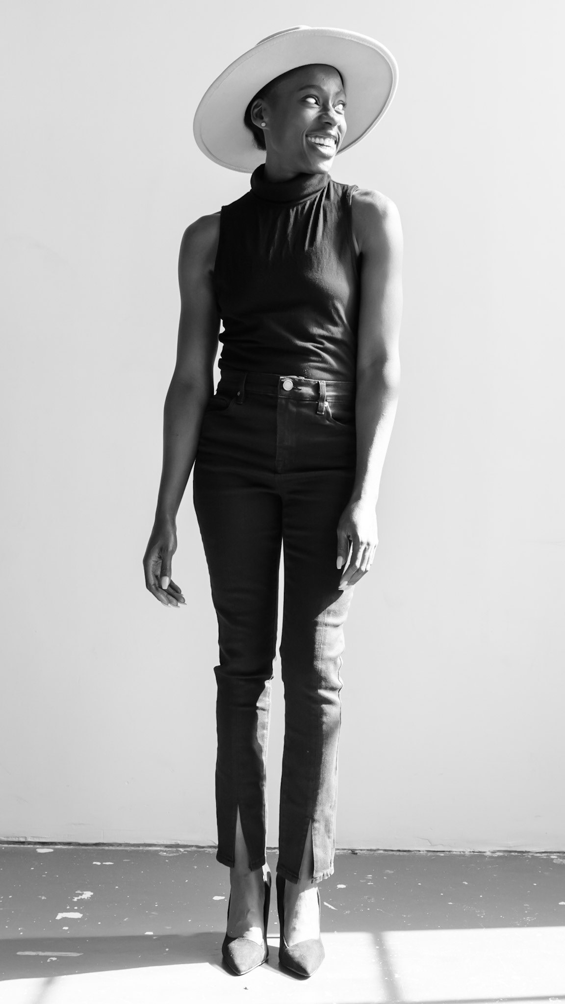 Ikeji Uju: Victoria Opemi stylishly dressed in all black with a top, jeans, and high heels. in San Francisco at a photography studio. Shot in Black and White. Ikeji Uju Photography