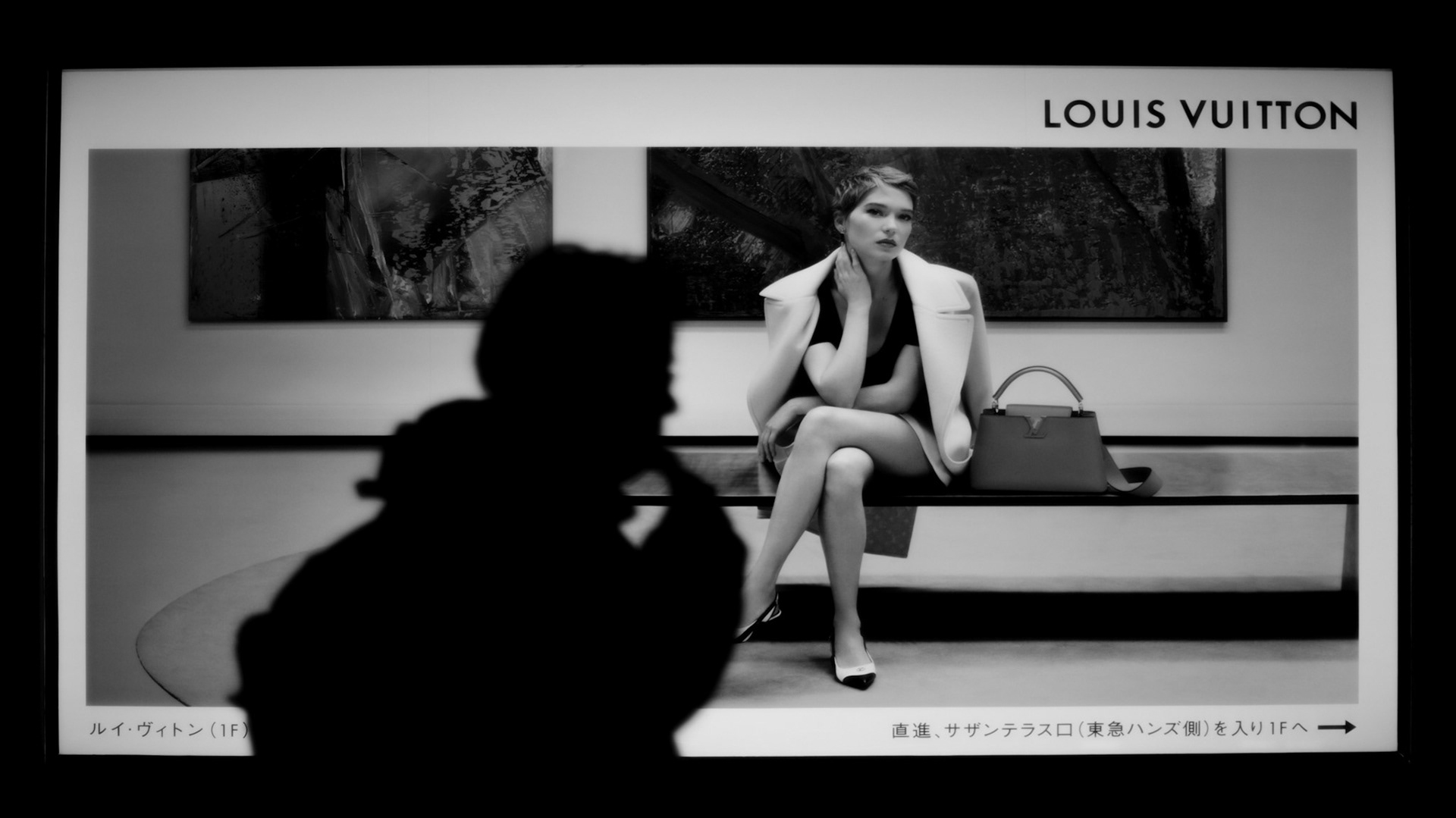 Captured by Ikeji Uju: A silhouette of a man standing in front of a Louis Vuitton Billboard in Tokyo, Japan.