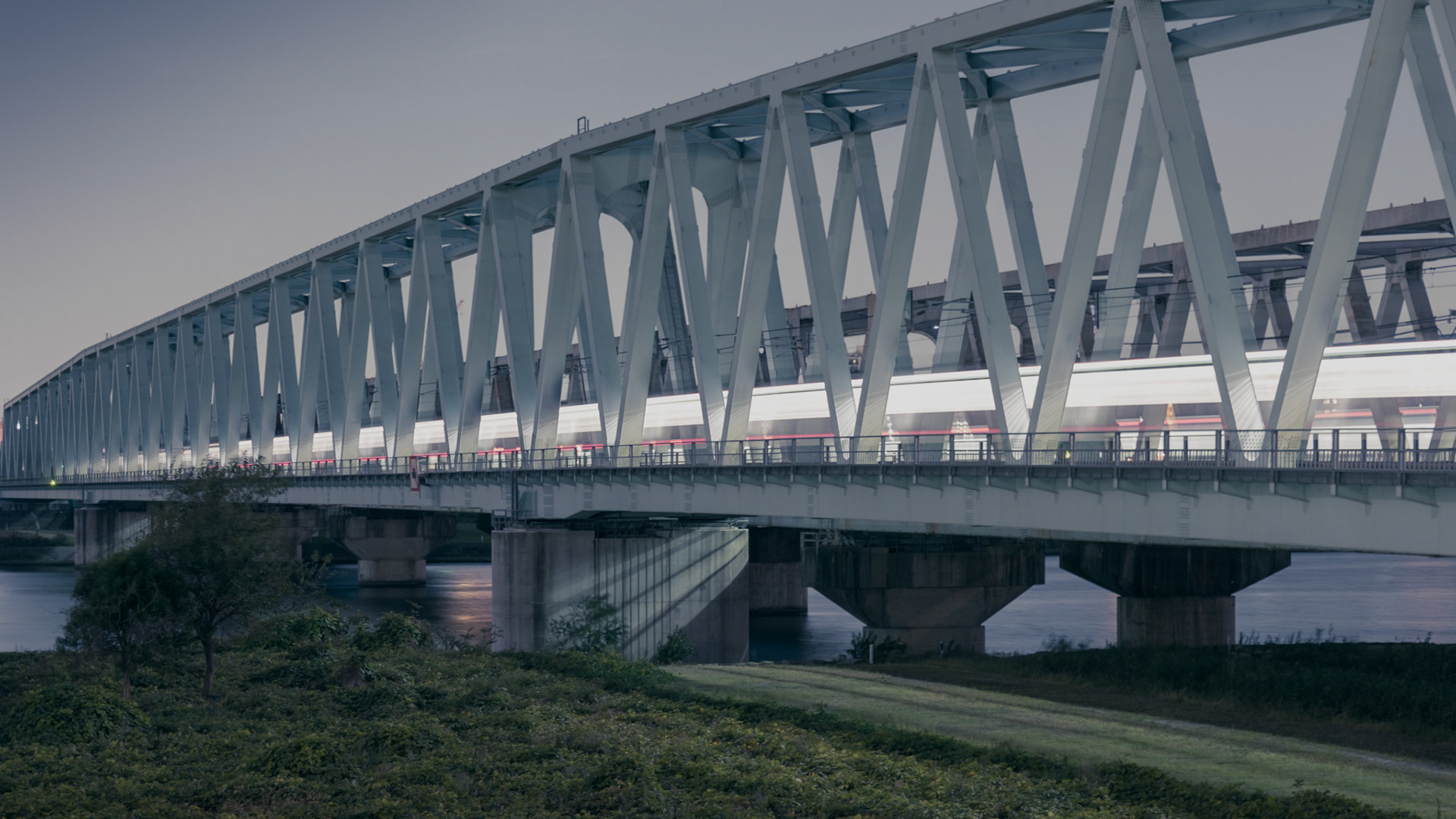 Ikeji Uju: Train crossing a bridge at night in Arakawa City, Tokyo, Japan. Ikeji Uju Photography
