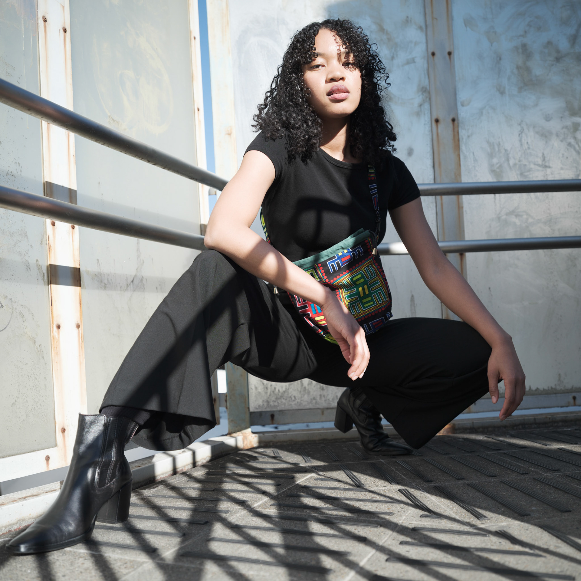 Ikeji Uju:  Emily Osas, a stunning mixed Japanese model elegantly adorned in a black crop top, black long pants, and black long coat set against the backdrop of Nakameguro City, Tokyo, Japan. Ikeji Uju Photography