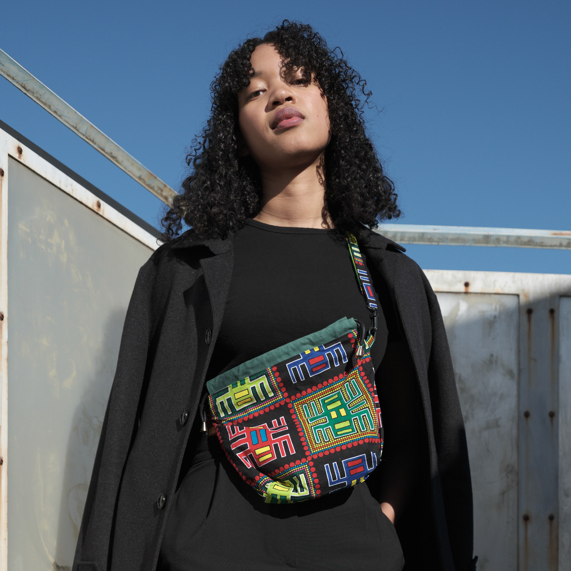 Ikeji Uju:  Emily Osas, a stunning mixed Japanese model elegantly adorned in a black crop top, black long pants, and black long coat set against the backdrop of Nakameguro City, Tokyo, Japan. Ikeji Uju Photography