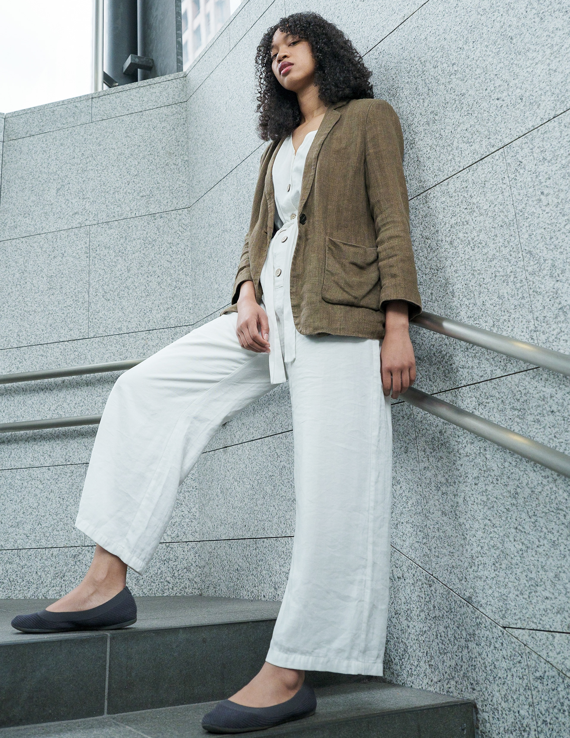 Ikeji Uju: Emily Osas elegantly adorned in a brown linen coat and white one-piece dress, set against the backdrop of Tokyo, Japan. Ikeji Uju Photography