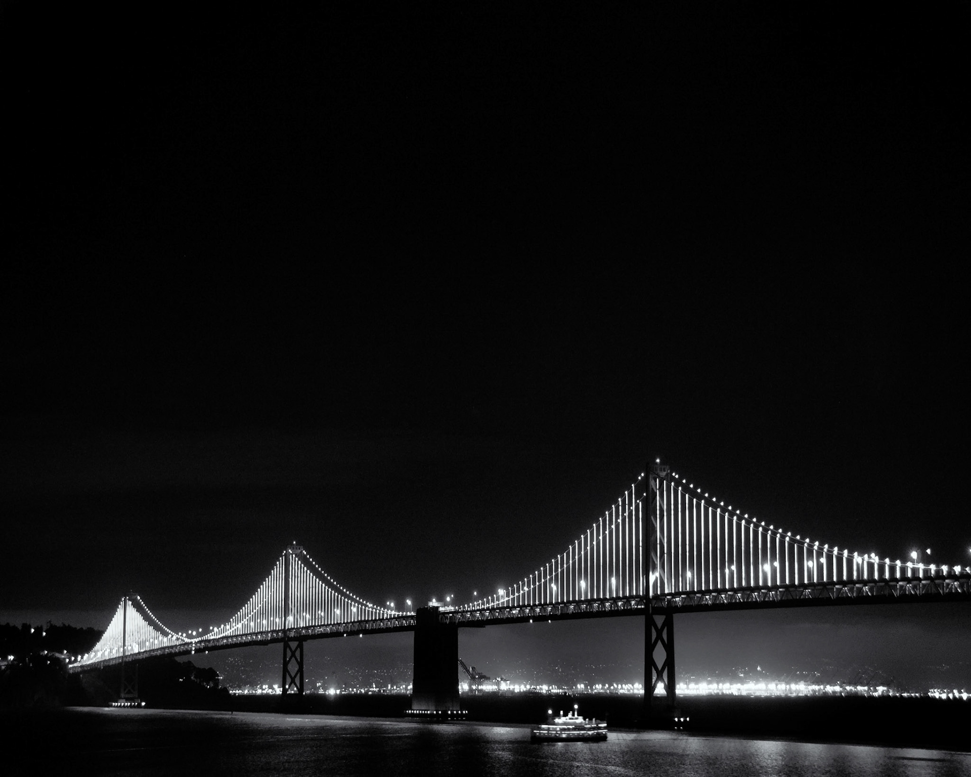What a site at night. San Francisco Bridge and a ferry boat cruising under and the lights of Oakland California in the background. It was a starless yet beautiful night.