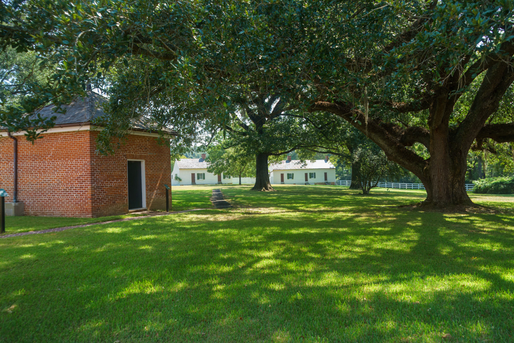 Smoke House with some Slave Quarters in the distance