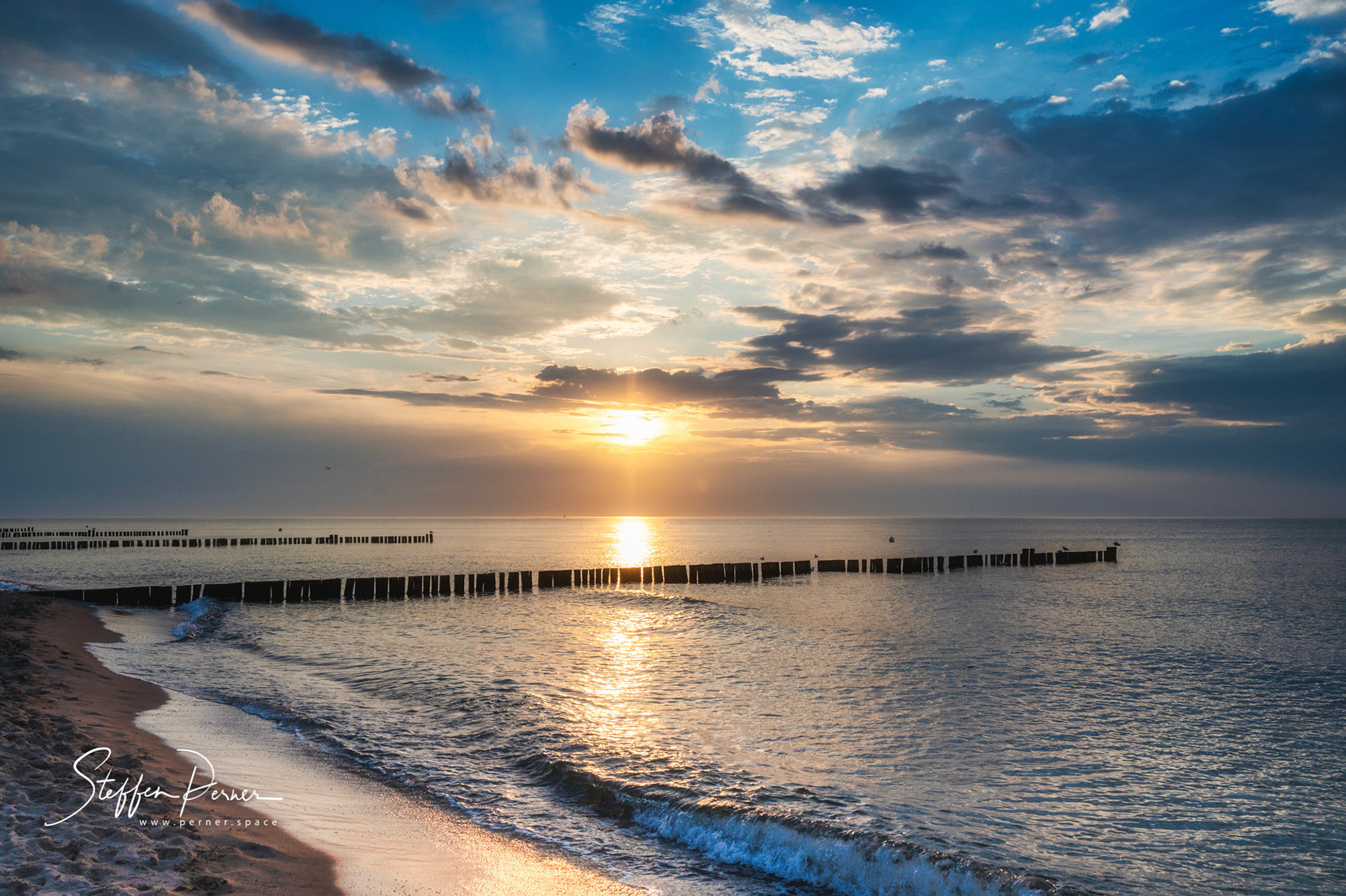 Sun set and groyne at baltic sea