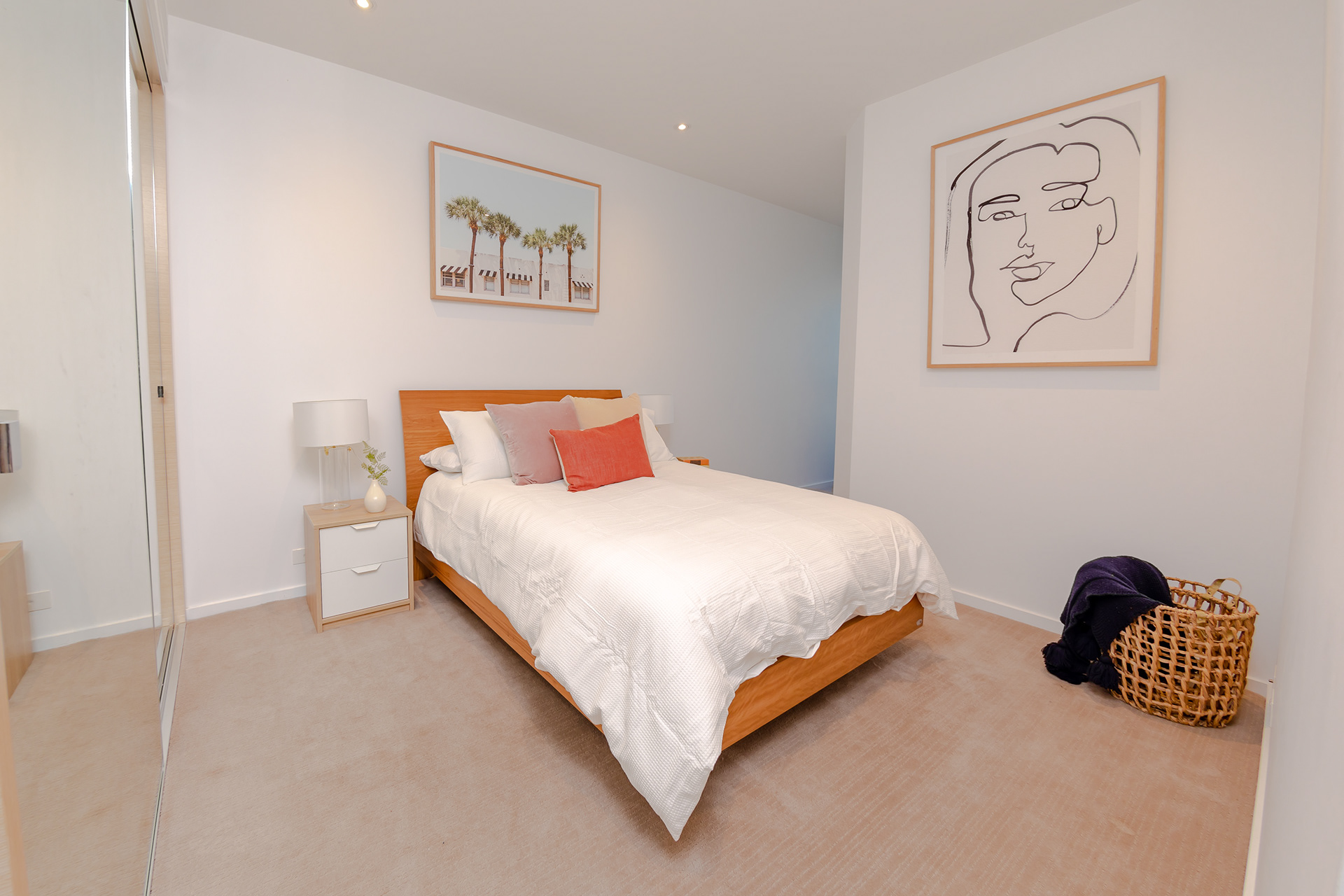 Bright bedroom with neutral furnishings and wall art