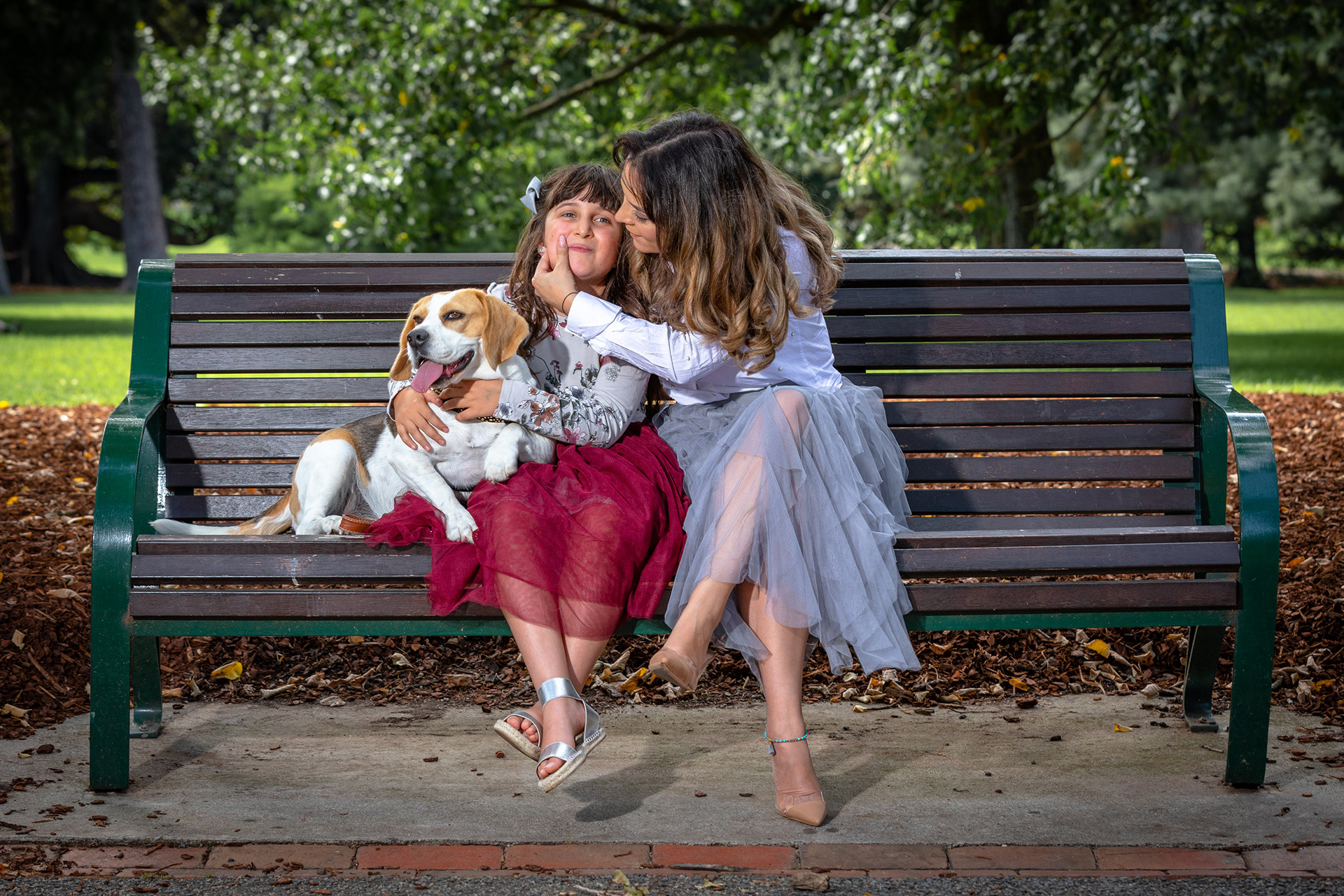 Parent and child sitting on a park bench