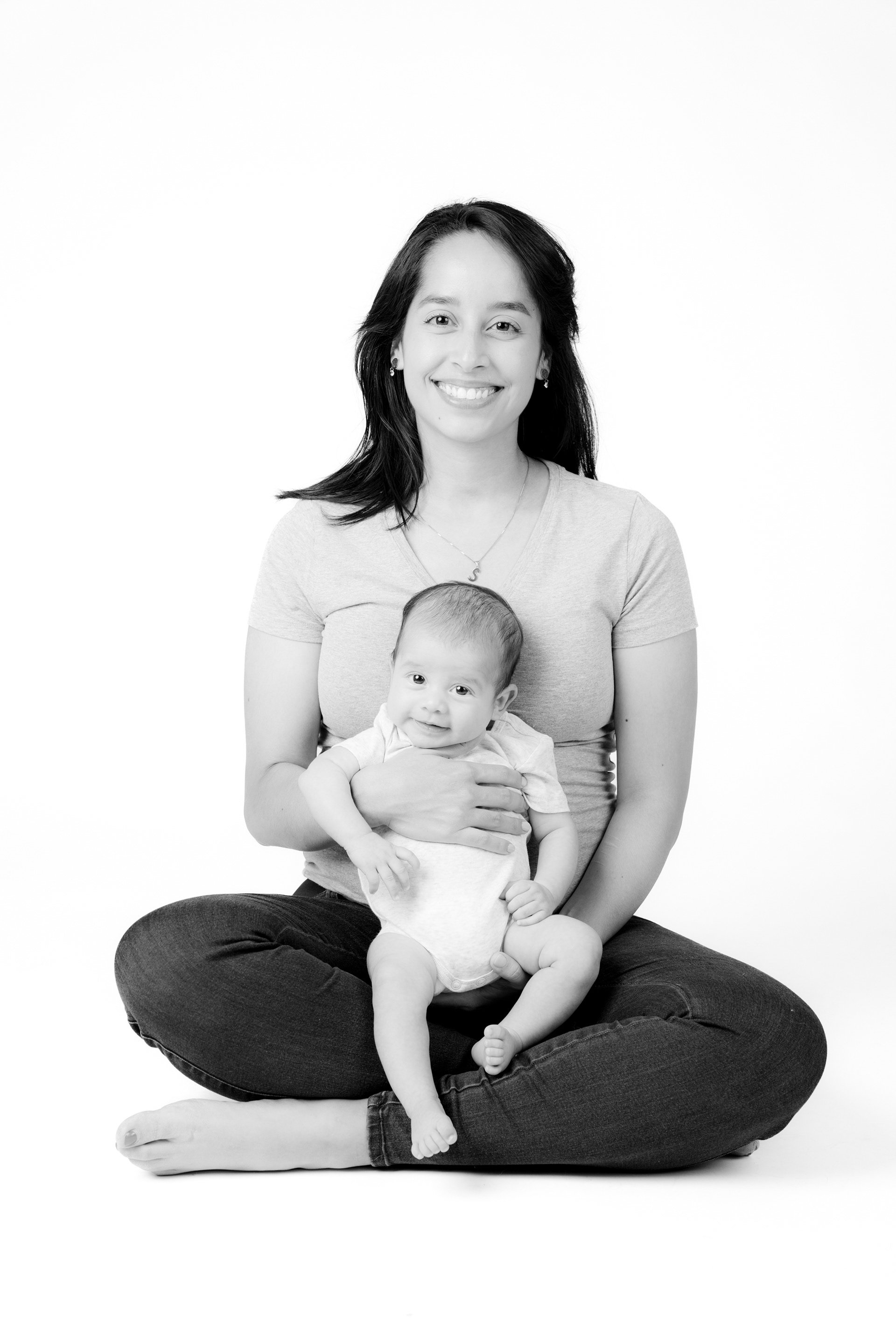 Black-and-white portrait of a seated parent holding a baby