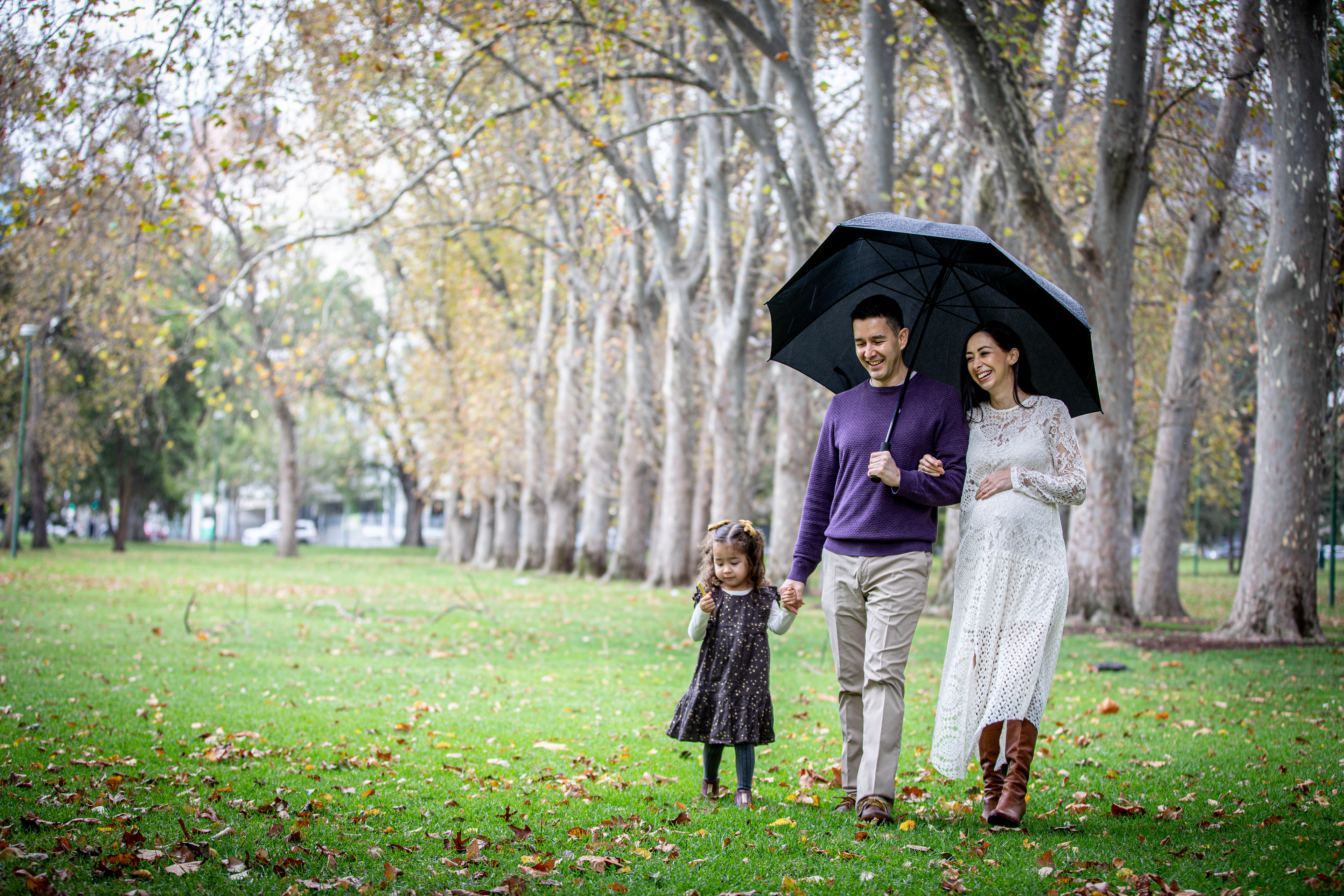 Couple standing beneath an umbrella in a park