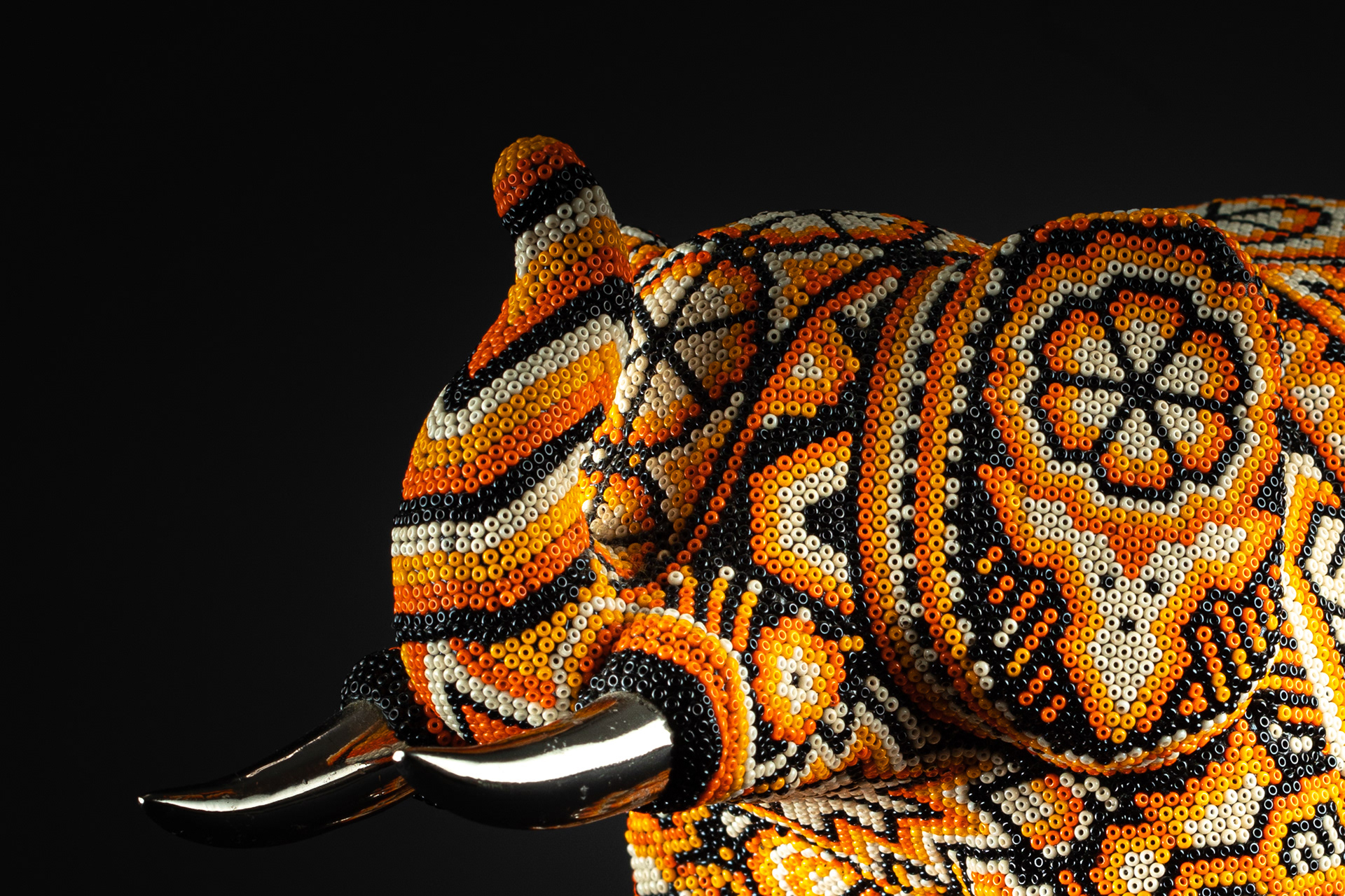 Side view of an elephant sculpture covered in colourful beadwork