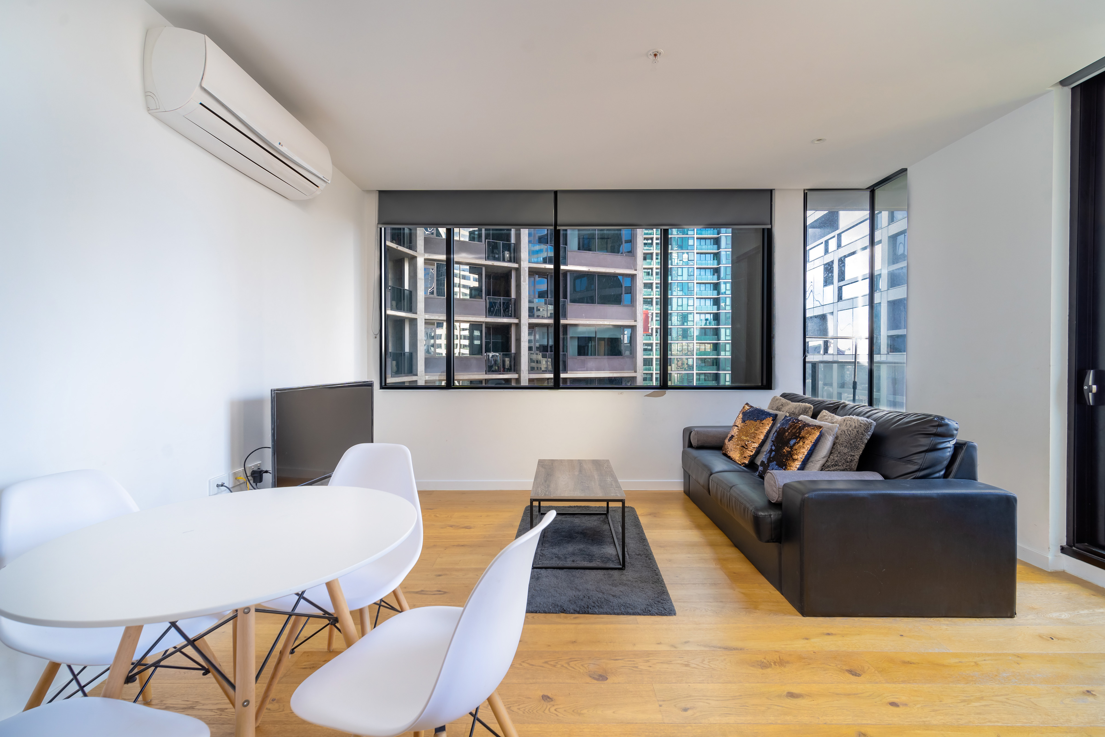 Apartment dining area with timber floors and large windows