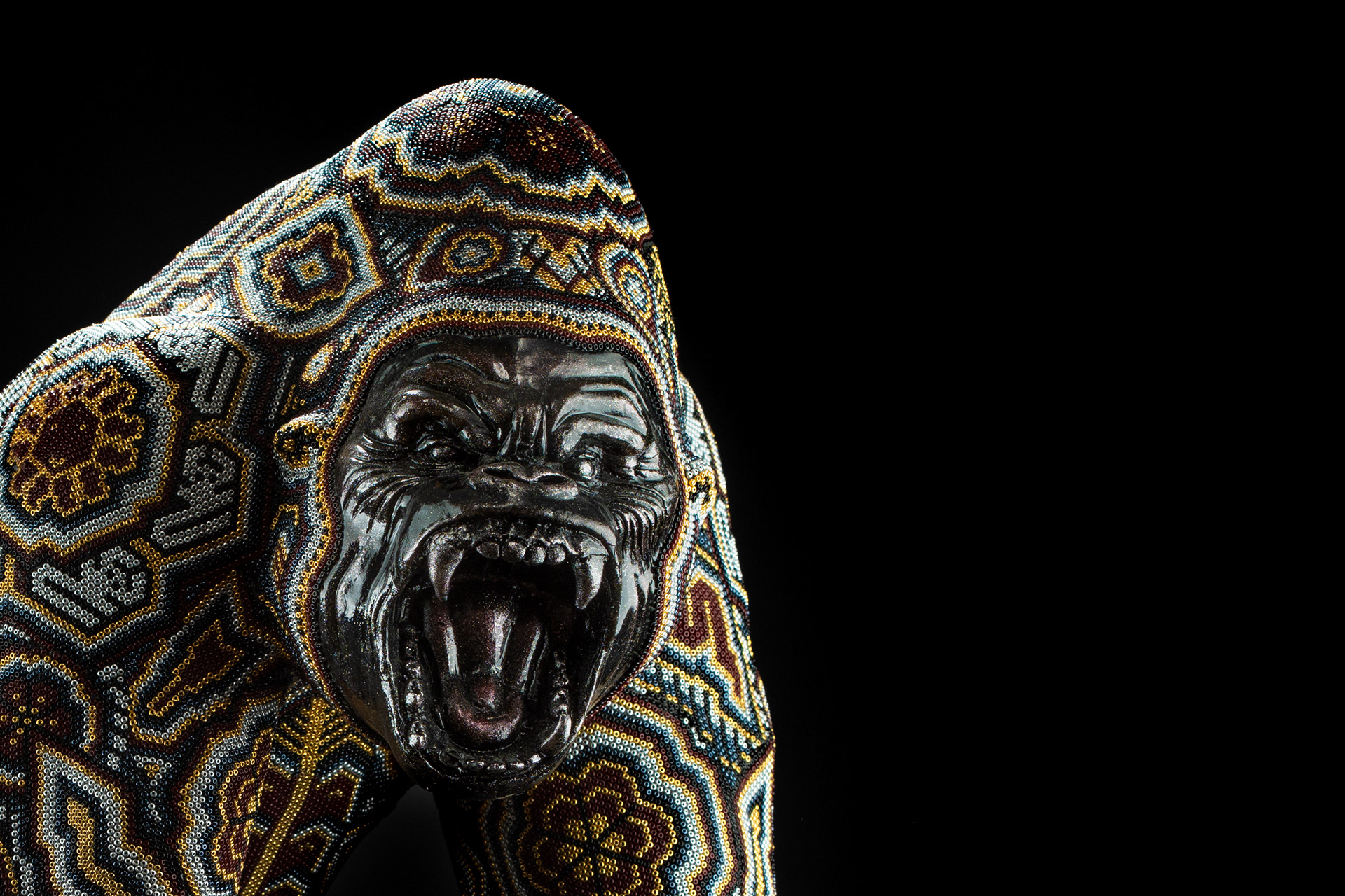 Close-up of a gorilla sculpture decorated with patterned beadwork