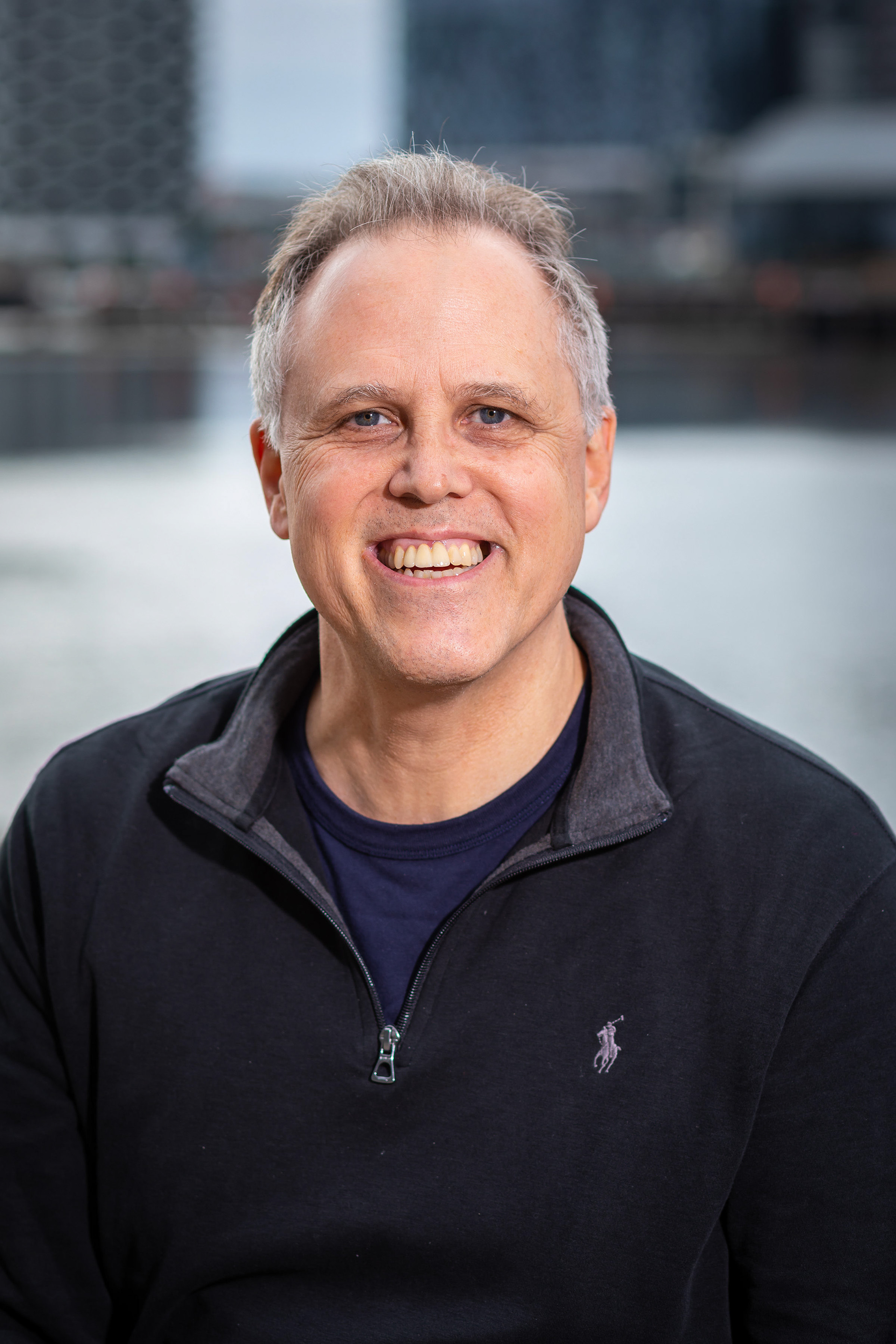 Smiling headshot in a black polo shirt