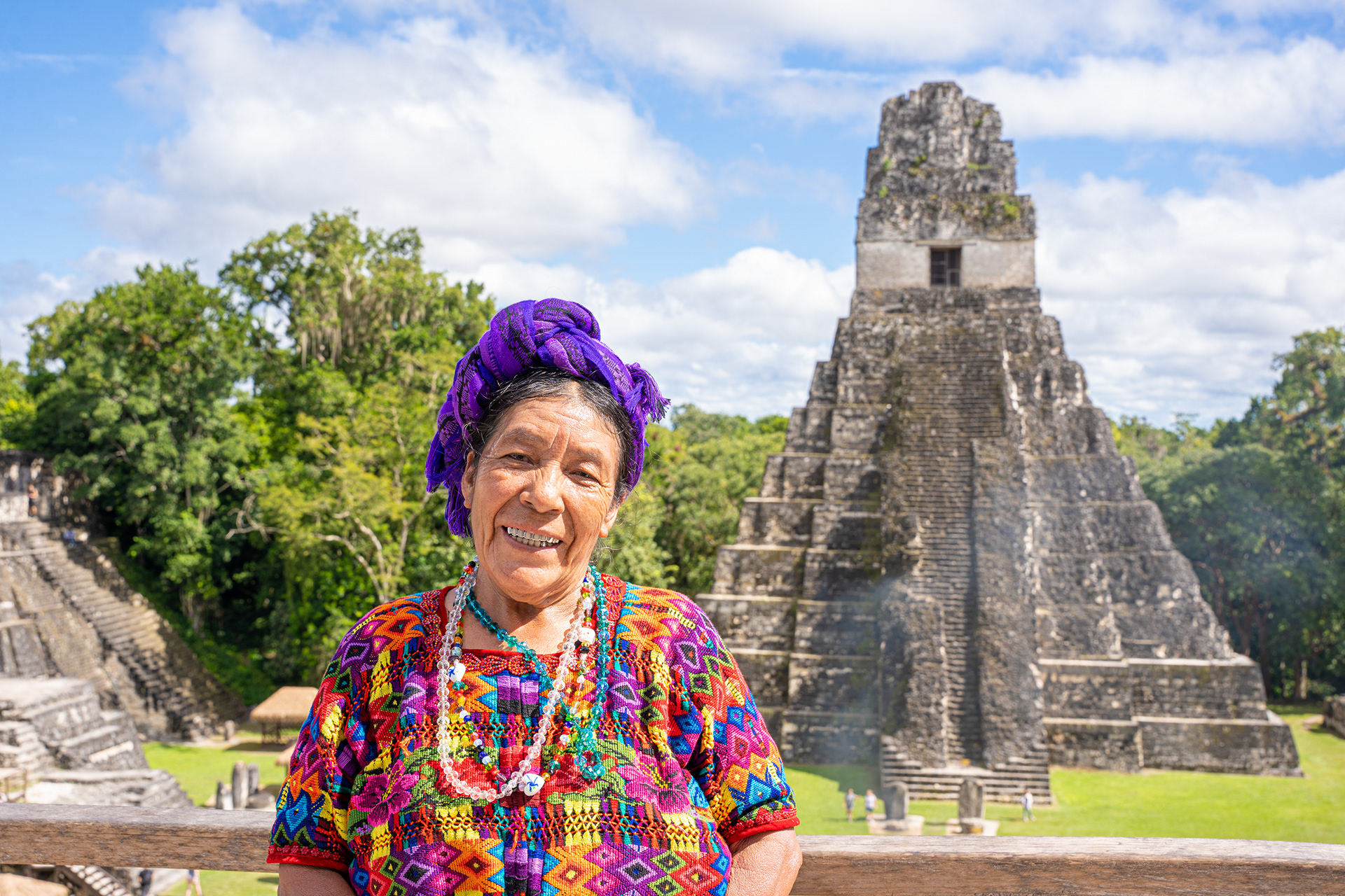 Portrait in colourful clothing beside an ancient stone temple