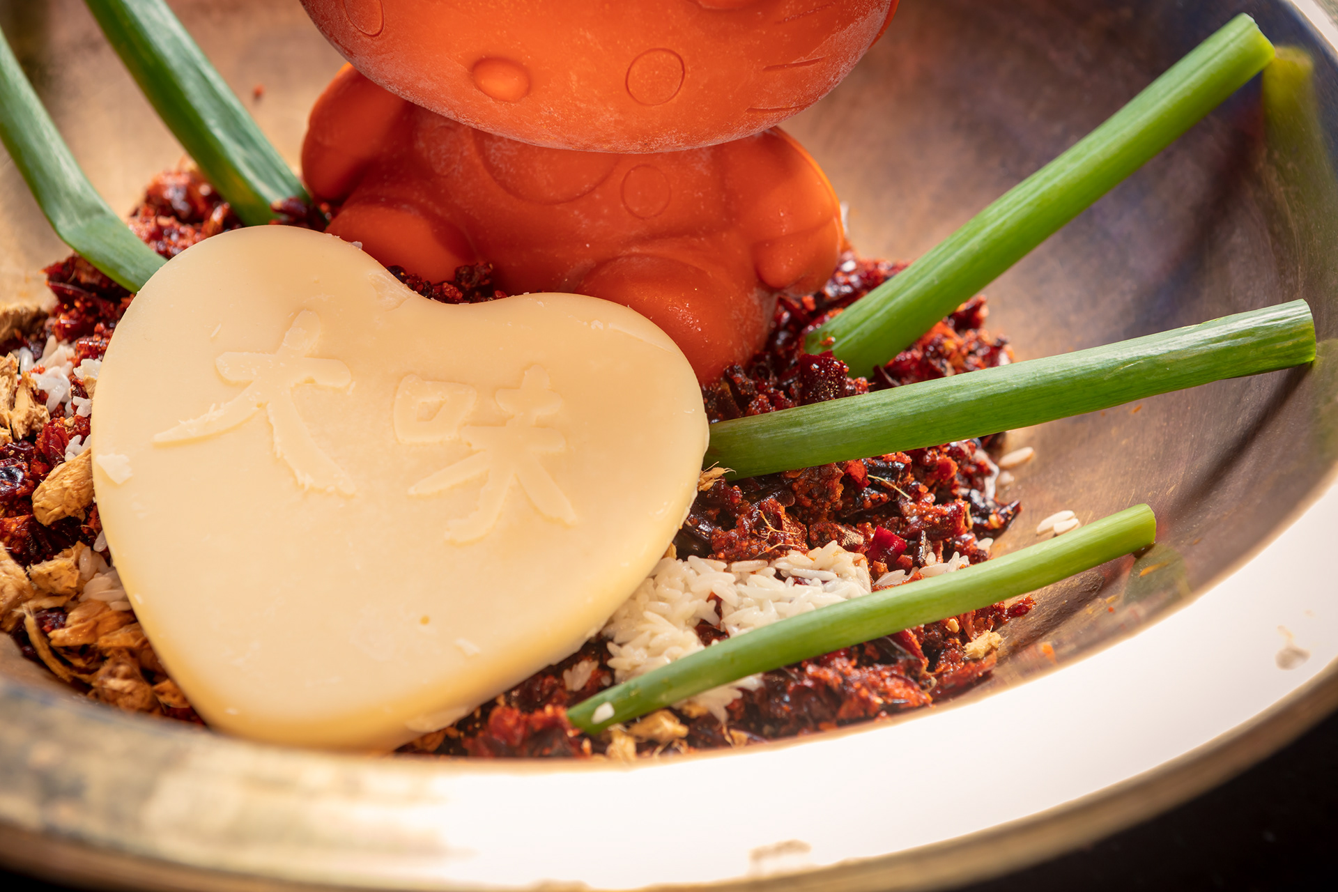 Chef spooning sauce onto a colourful plated dish