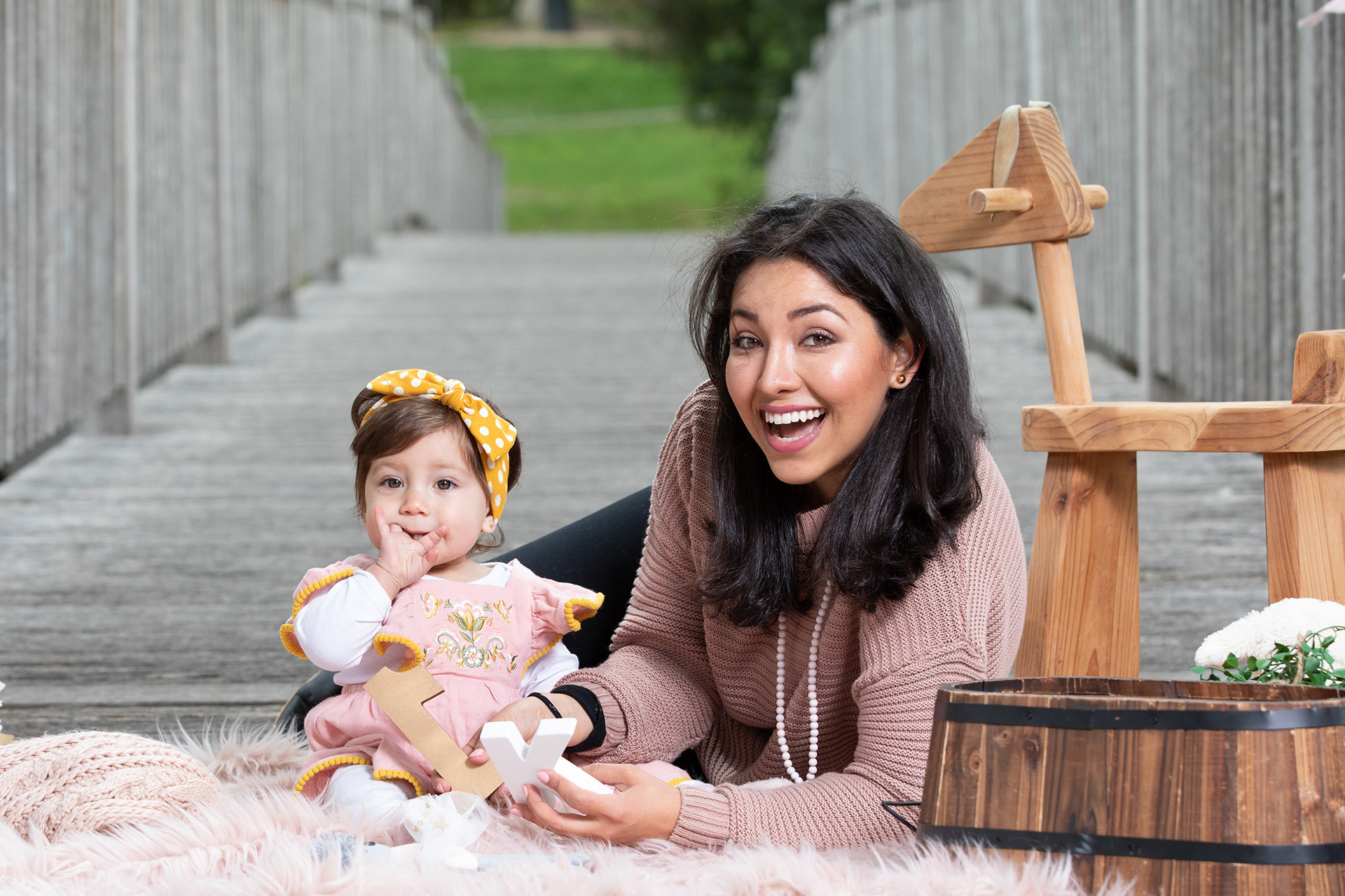 Parent and baby beside a pink birthday cake