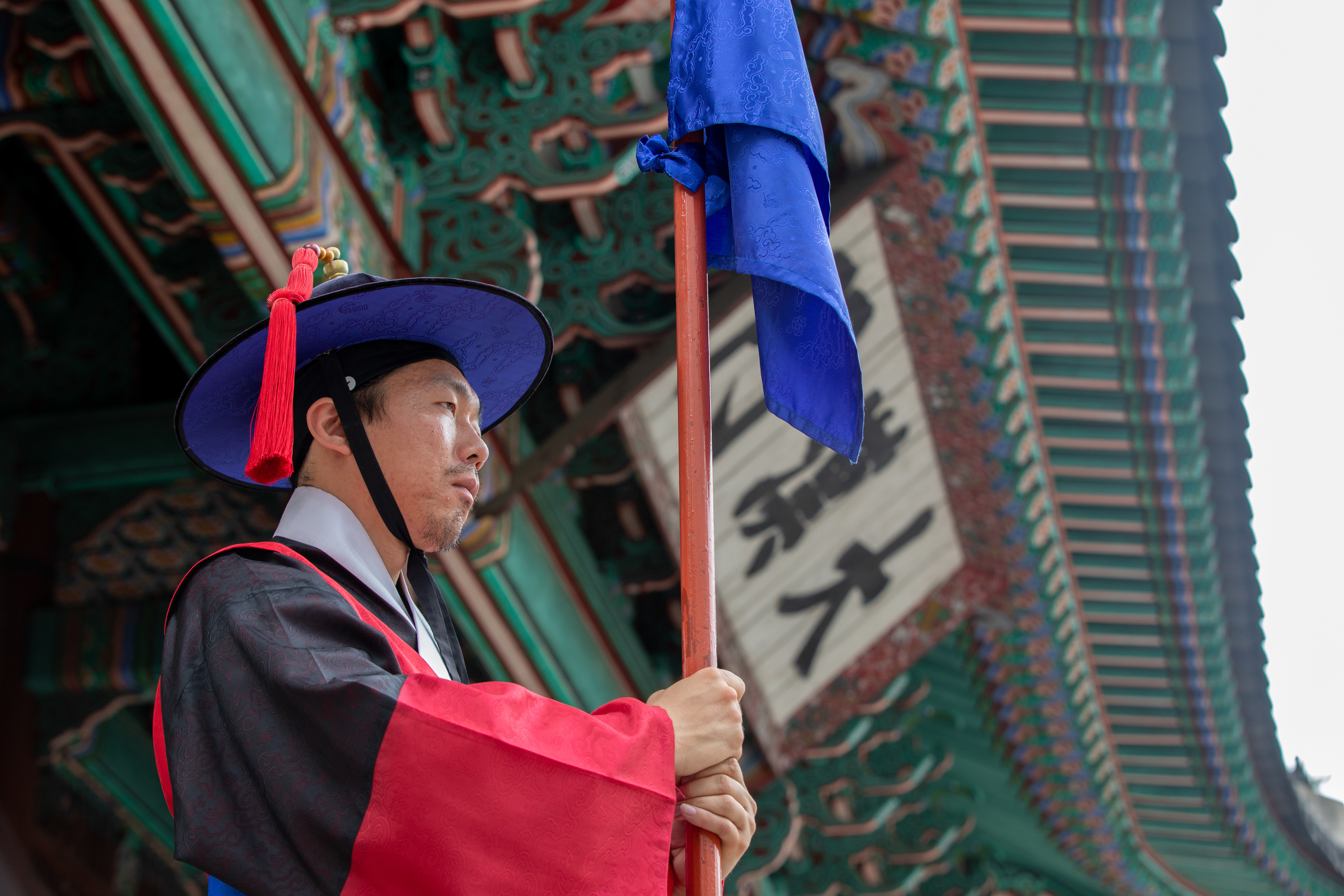 Ceremonial guard standing beneath an ornate palace roof