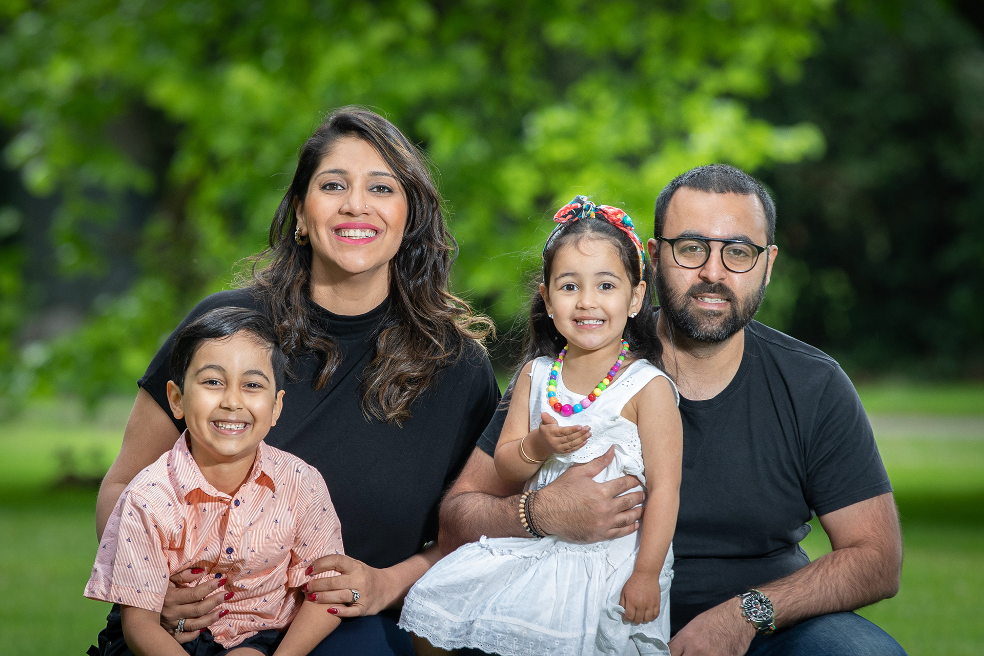 Family seated together in a green park