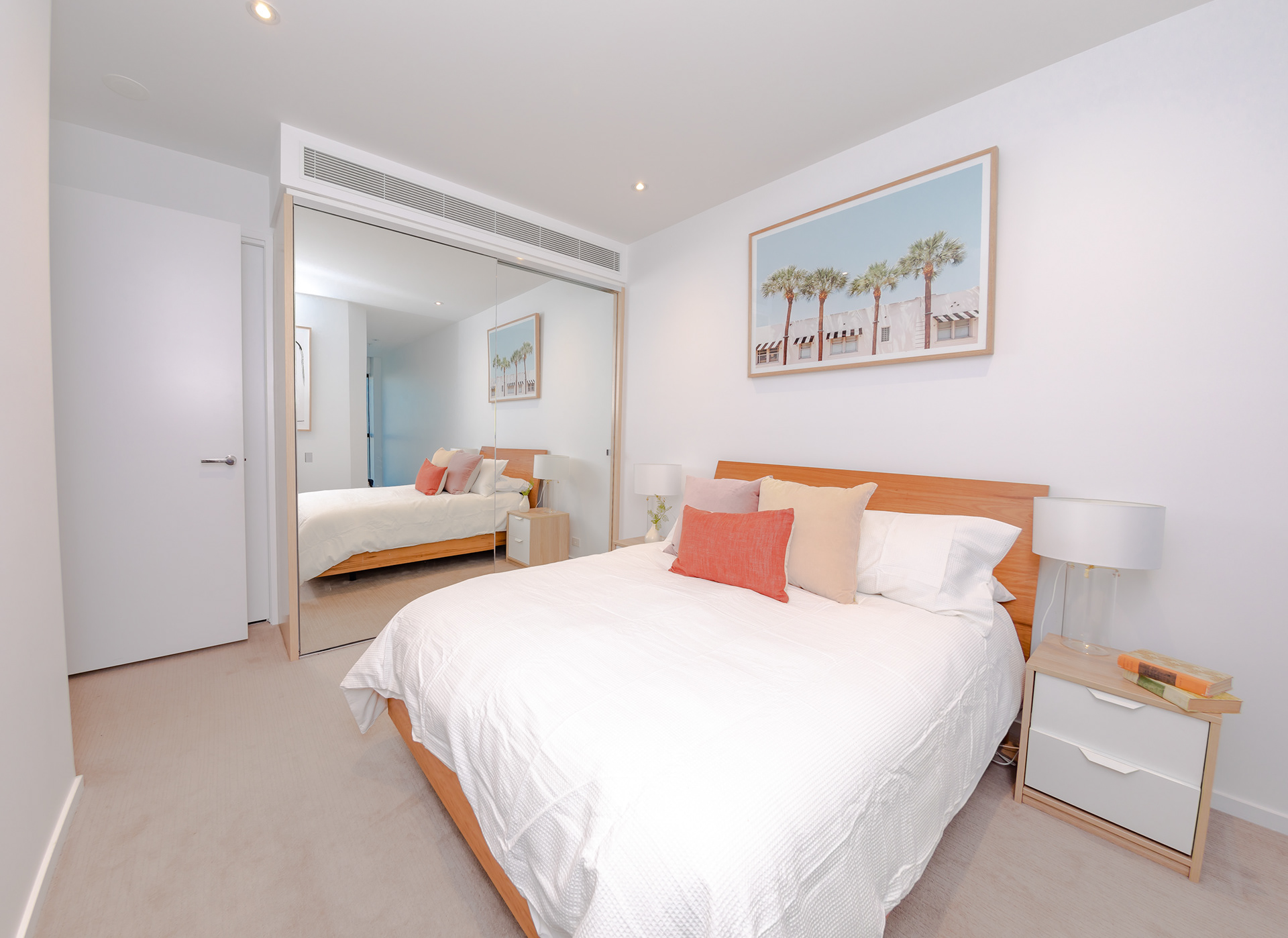 Bedroom with a white bed and framed artwork