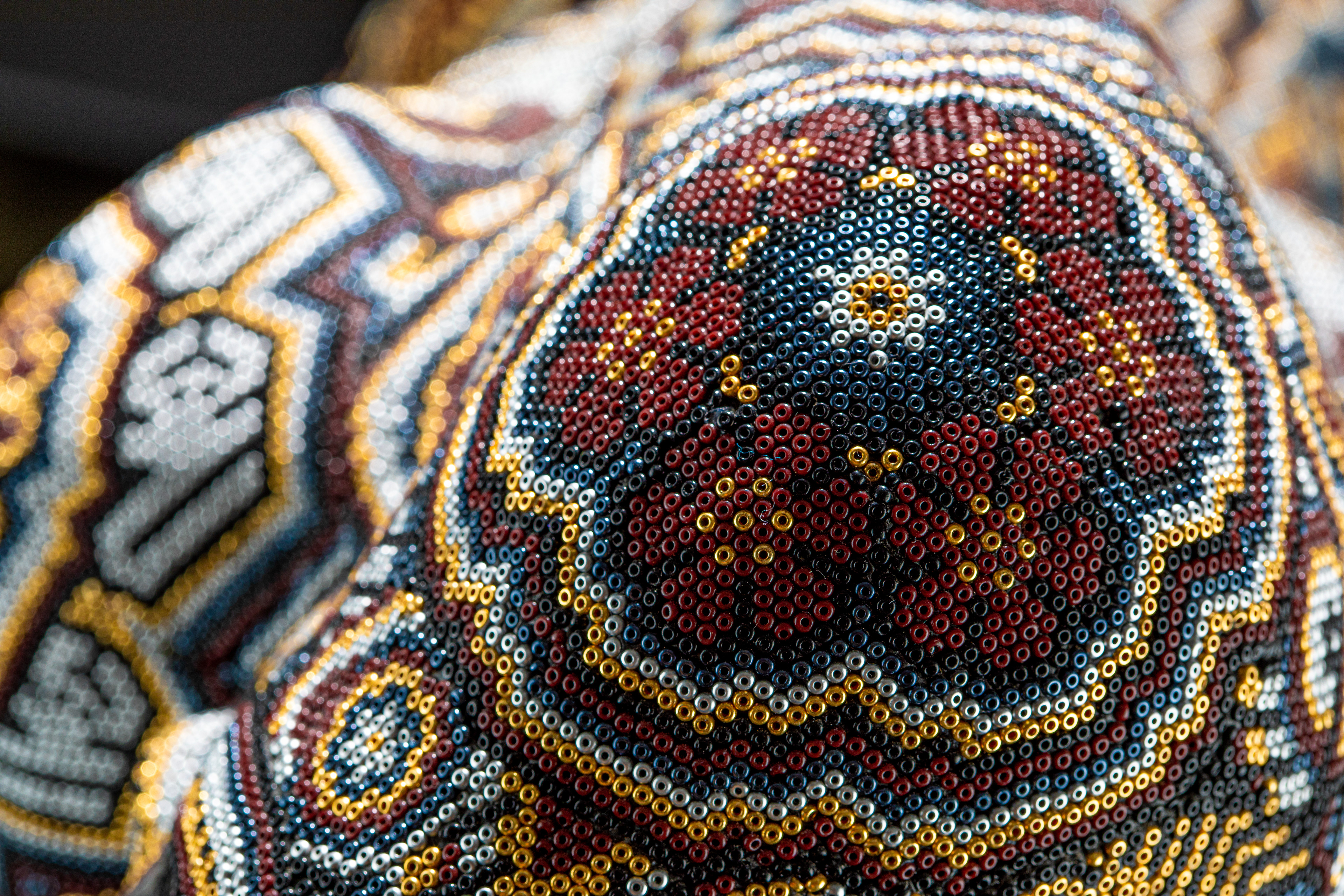 Detailed view of colourful beadwork on a sculpture