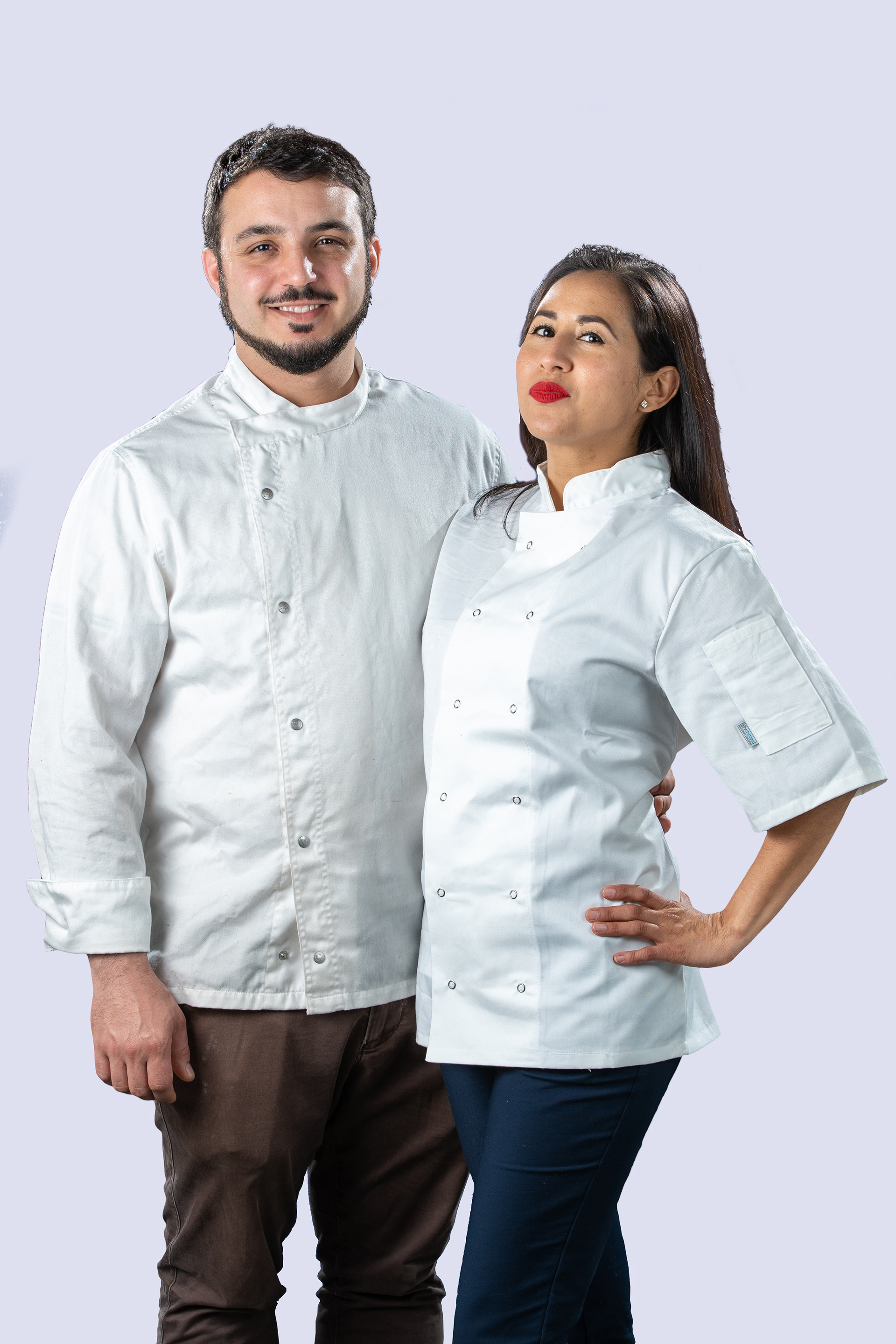 Couple standing together against a pale blue background