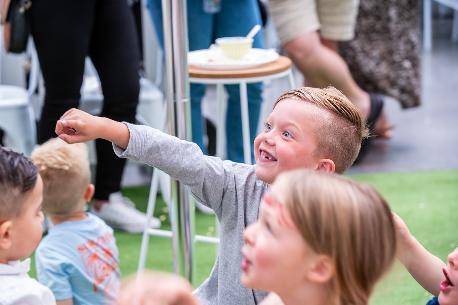 Child reaching forward during a party activity