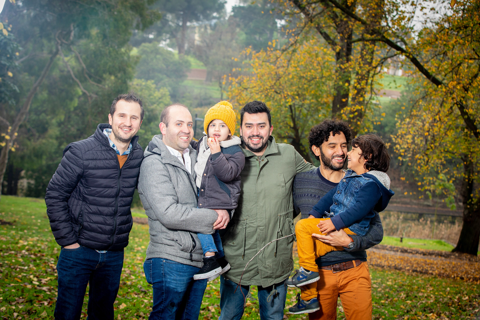 Family gathered beside a tree in a park