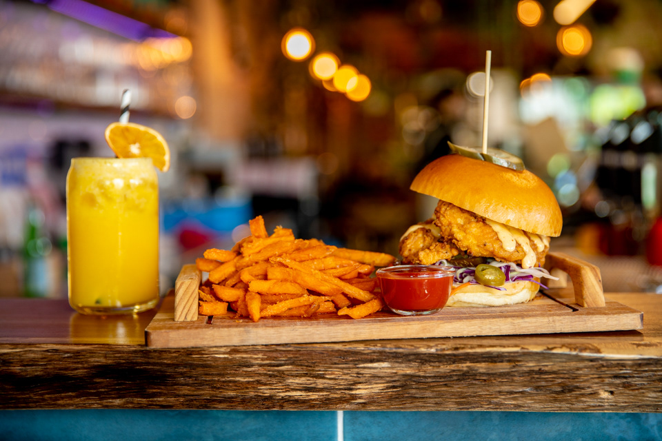 Burger, fries and an orange drink on a restaurant counter