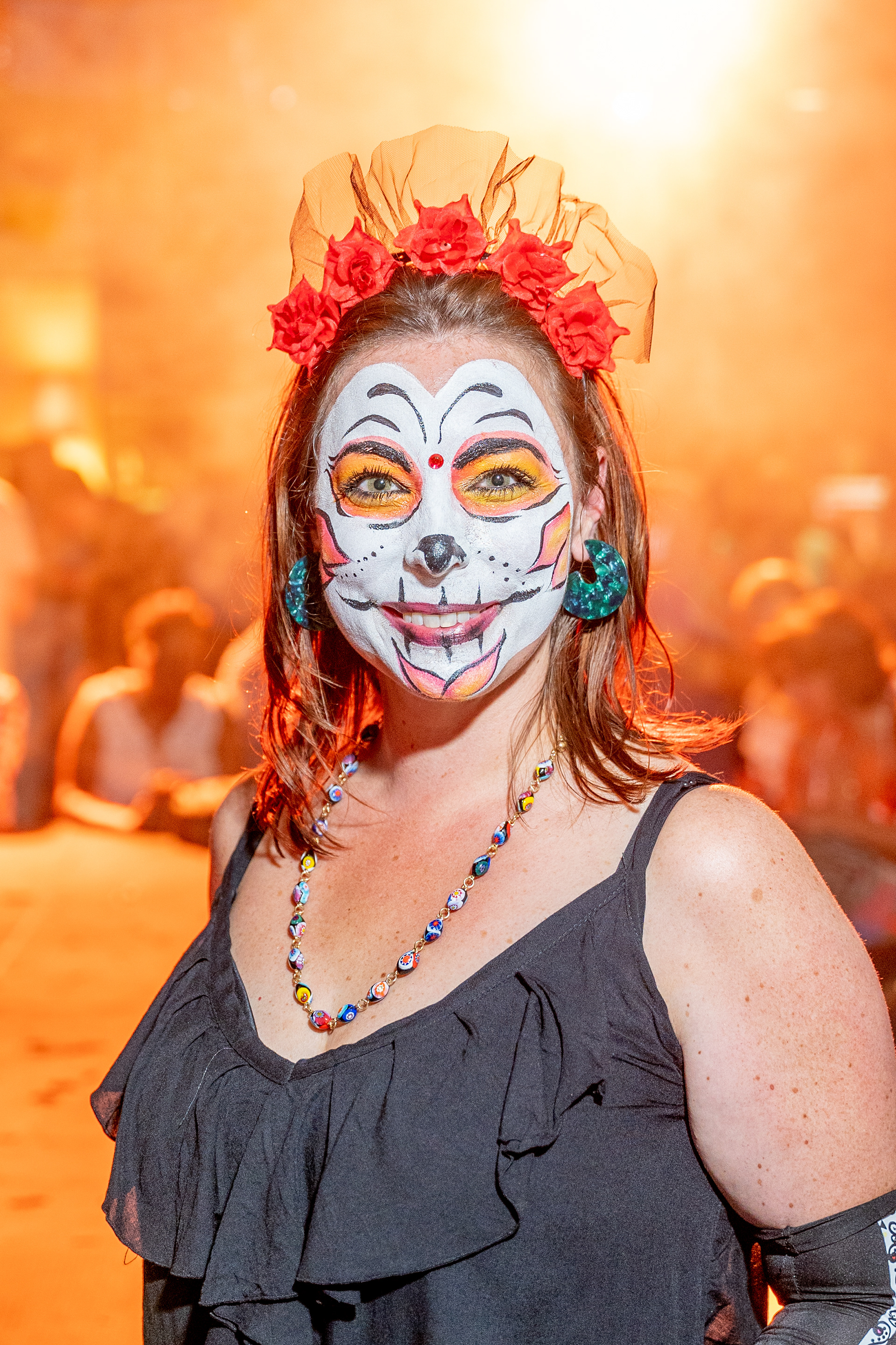 Portrait with skull face paint and a red flower crown