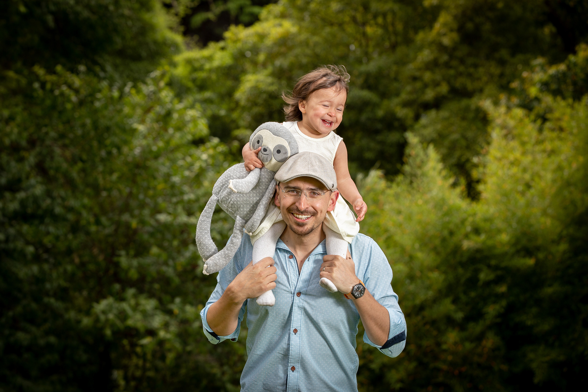 Child sitting on a parent’s shoulders outdoors