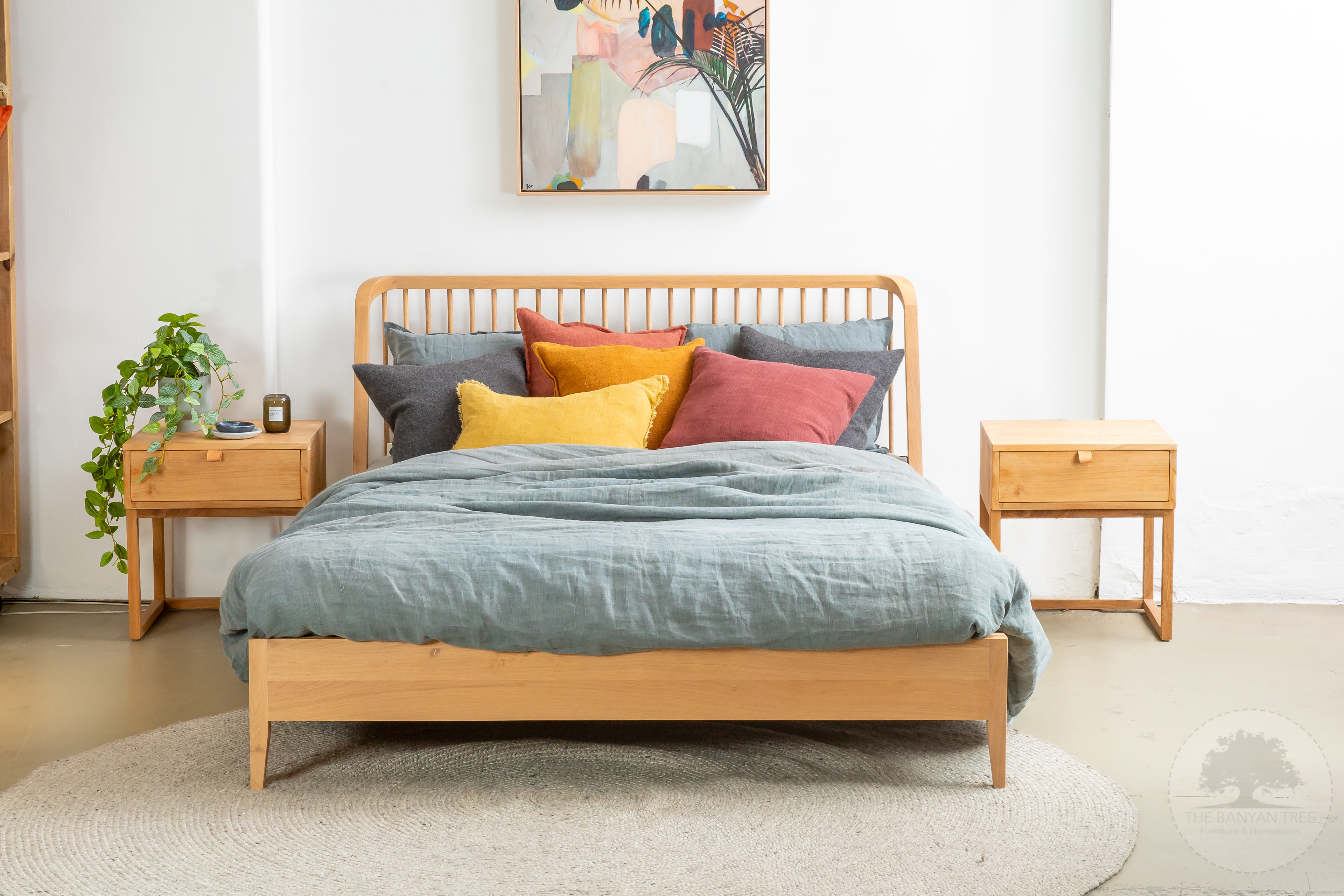 Bedroom setting with a timber bed and colourful cushions